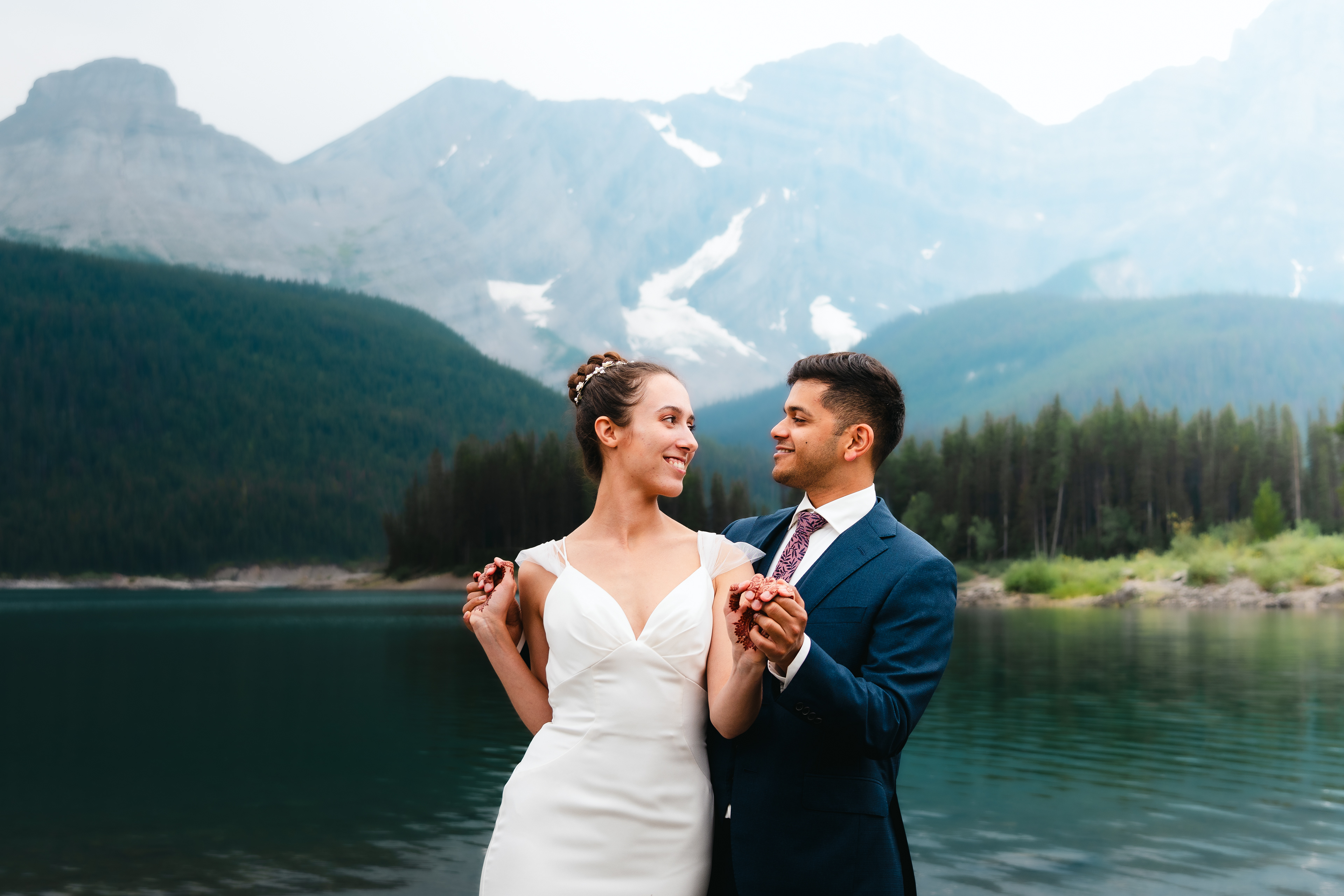 Sumit and Alida holding hands, looking at each other, and smiling.