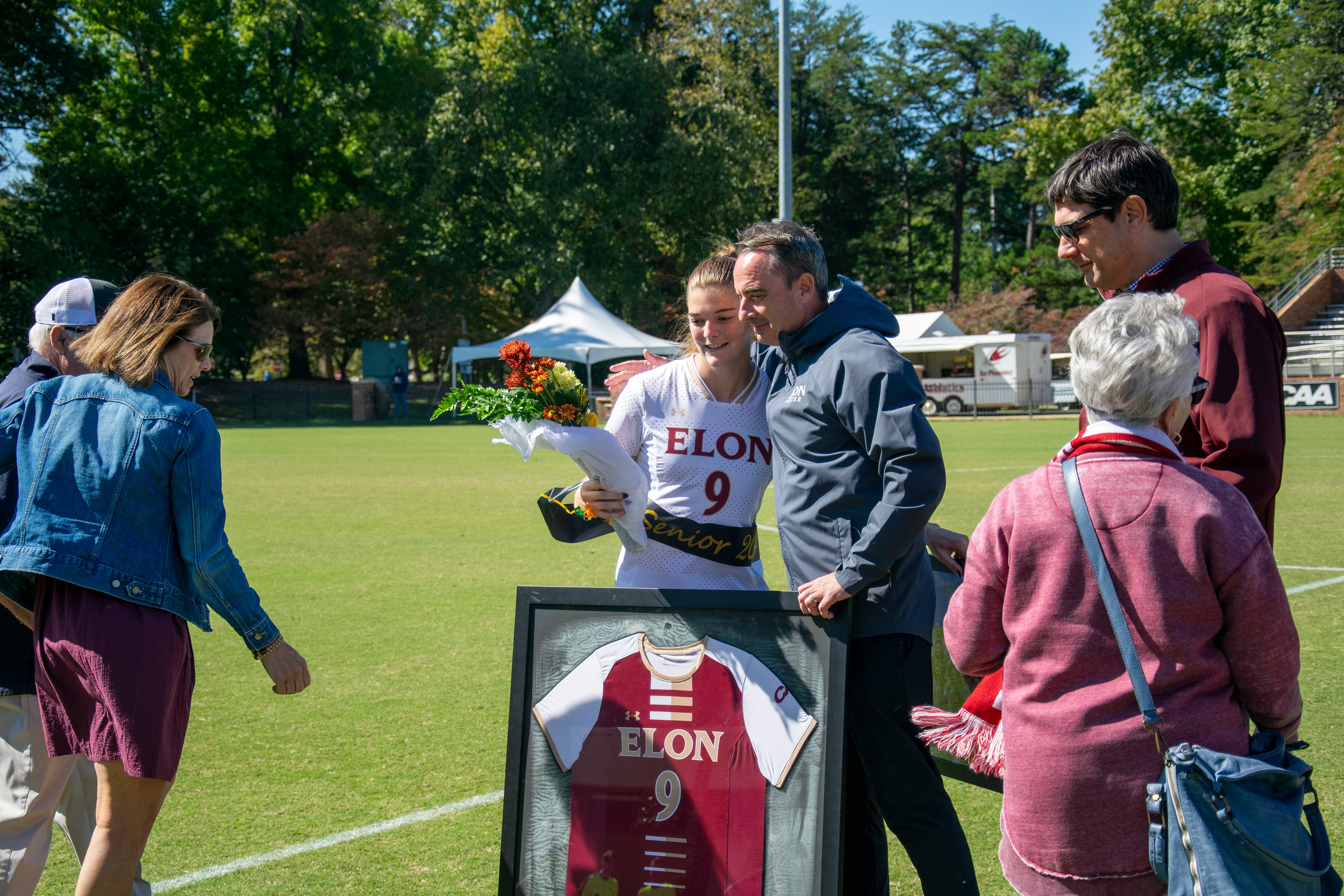 Senior Katie Lowe and head coach Neil Payne share a moment together during Elon’s Senior Day ceremony at Rudd Field on Oct. 8, 2023. Photo by Katherine Martin.