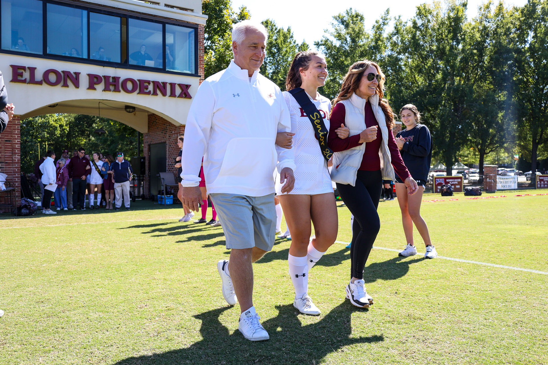 Isabelle Paradoski escorts her family onto Rudd Field for Elon’s Senior Day ceremony on Oct. 8, 2023. Photo by Jacob Kisamore.