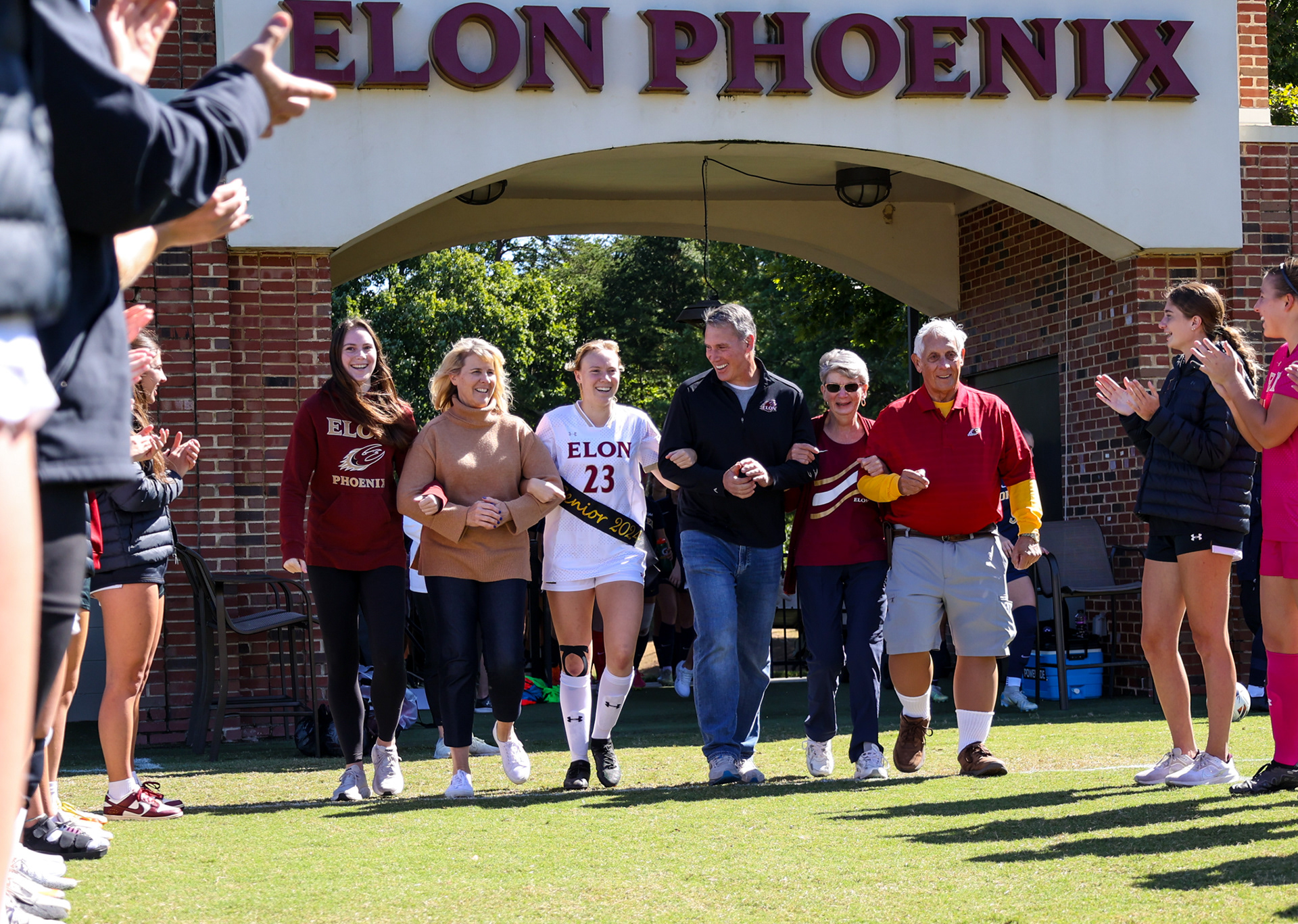 Senior Kerri Coffman escorts her family onto Rudd Field during Elon’s Senior Day ceremony on Oct. 8, 2023. Photo by Jacob Kisamore.