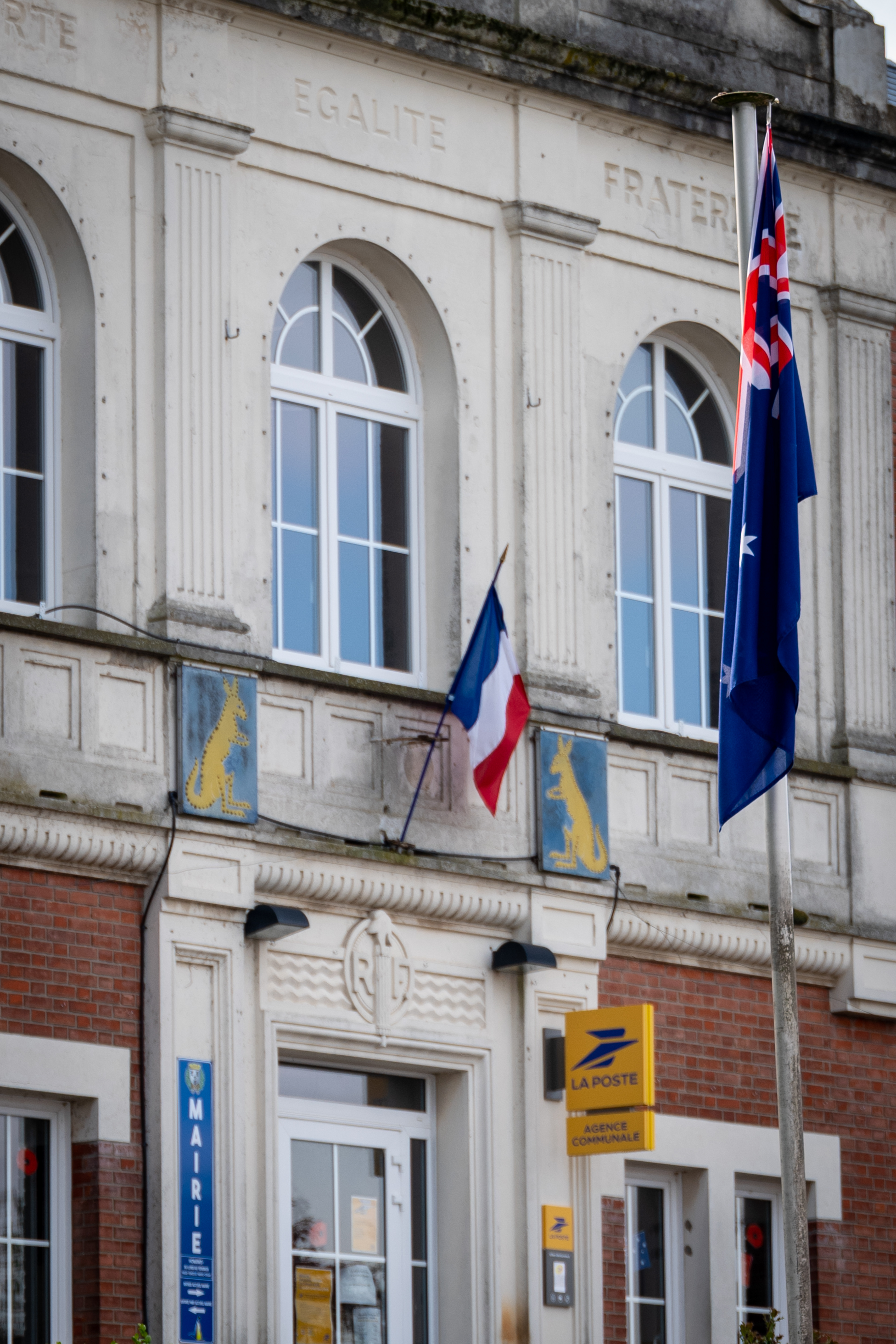 The façade of the Mairie, Villers-Bretonneux, France, May, 2026, showing the French tricolour and the town's official kangaroo emblem. The word "Fraternité" is carved into the stonework above. A French  ‘Mairie’ is equivalent to a council chamber in Australia. Photo: Jon L Arthur