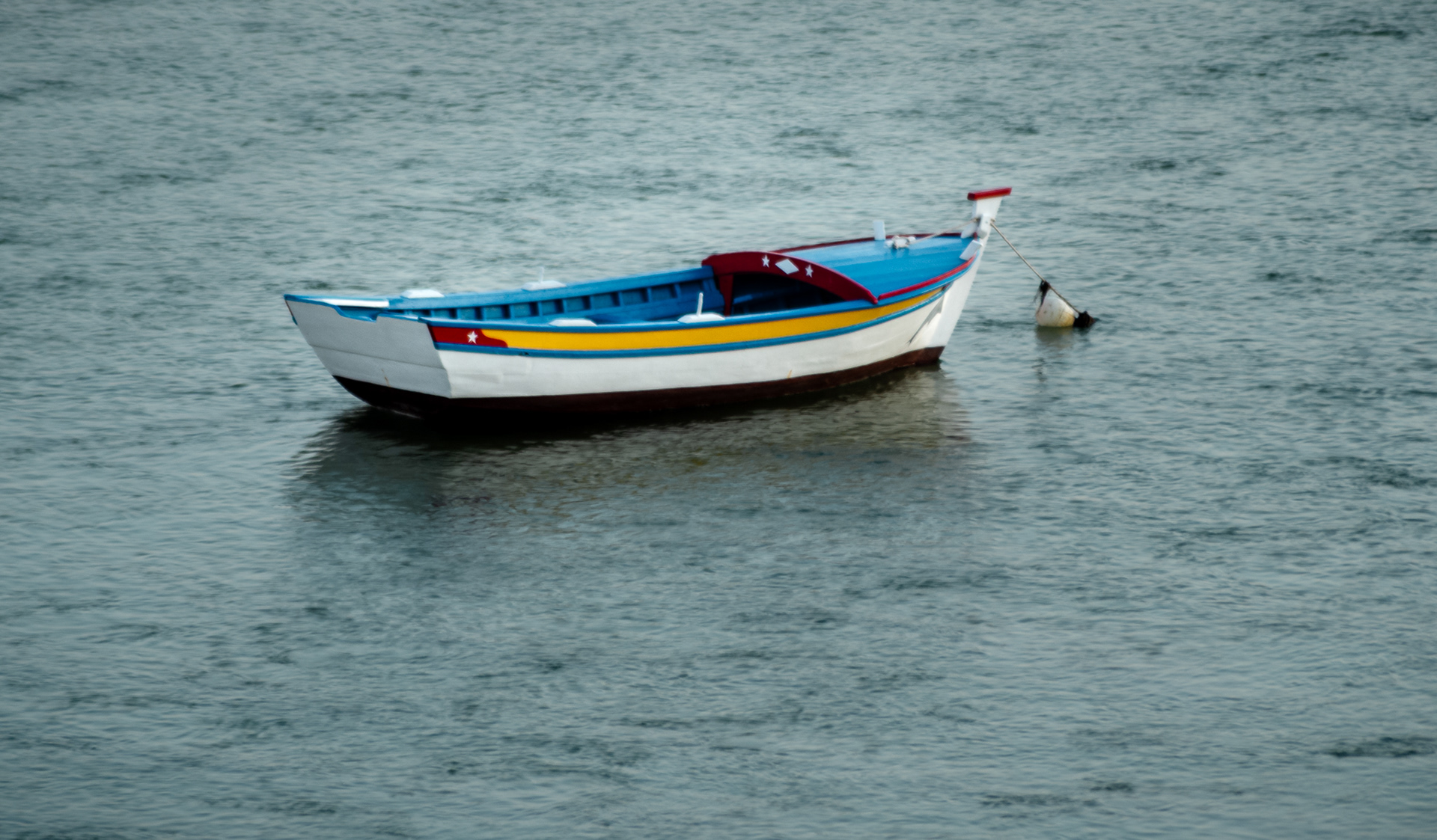 small boat floating alone on calm water minimalist seascape fine art photography