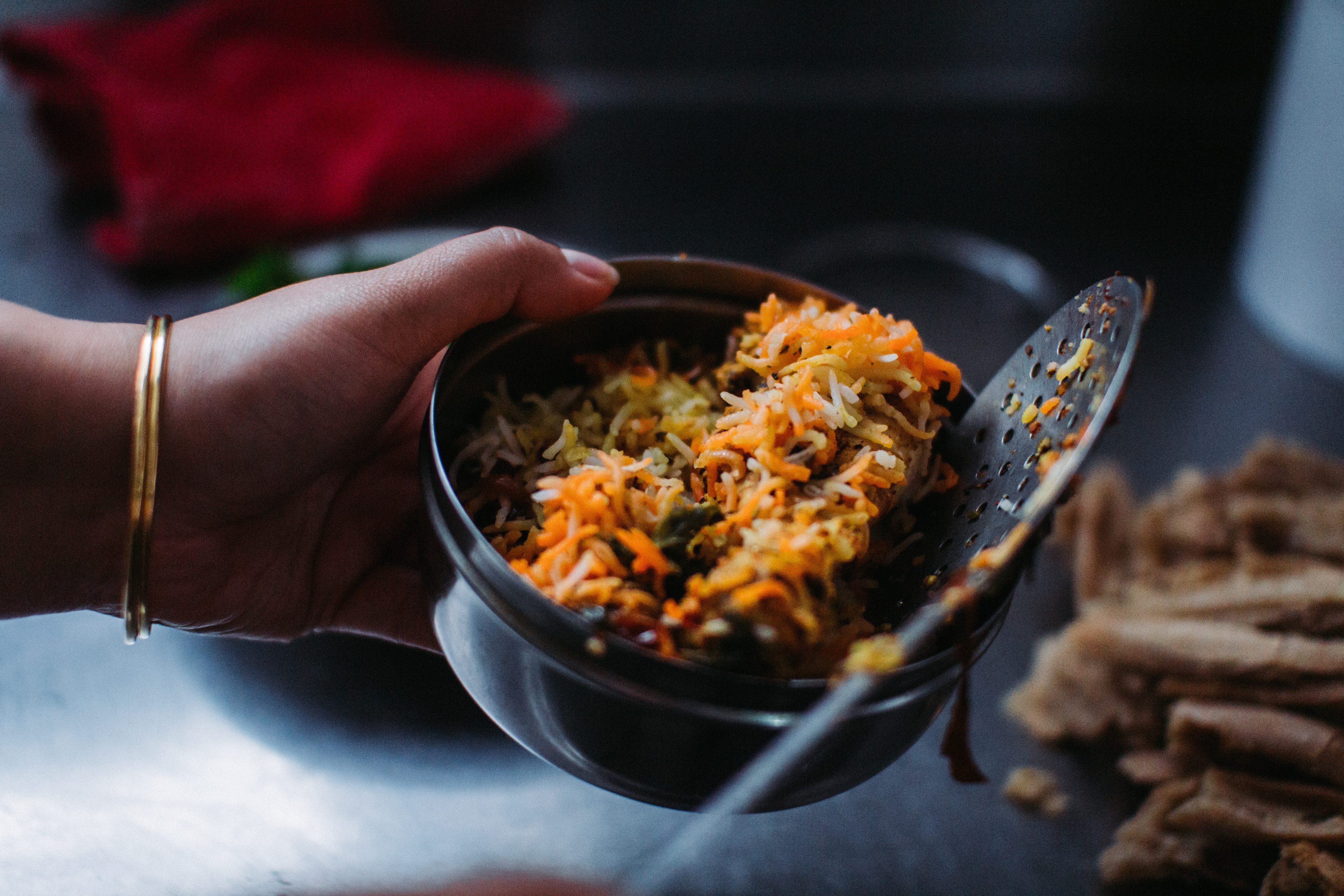 Sneha Shetty as "Aditi' scooping biryani into a steel tiffin, photo by Ankita Singh 2019