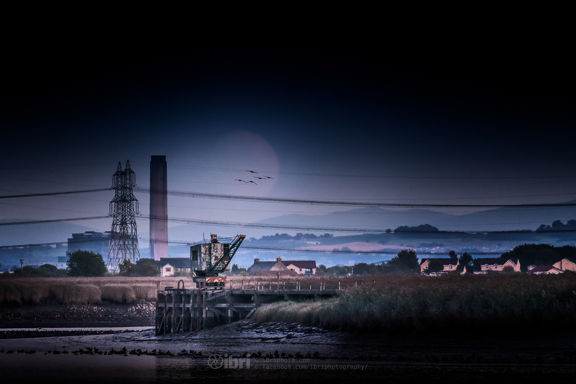 A near full moonrise over the River Forth and the abandoned munitions crane on the Admiralty Pier, River Forth