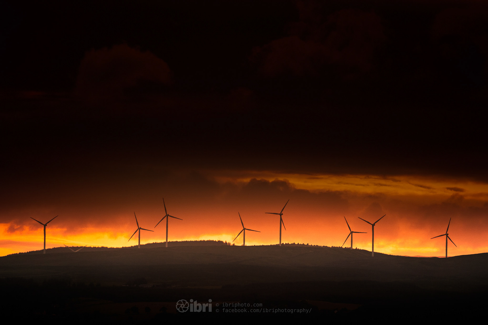 Wind turbines in the distance against a sunset
