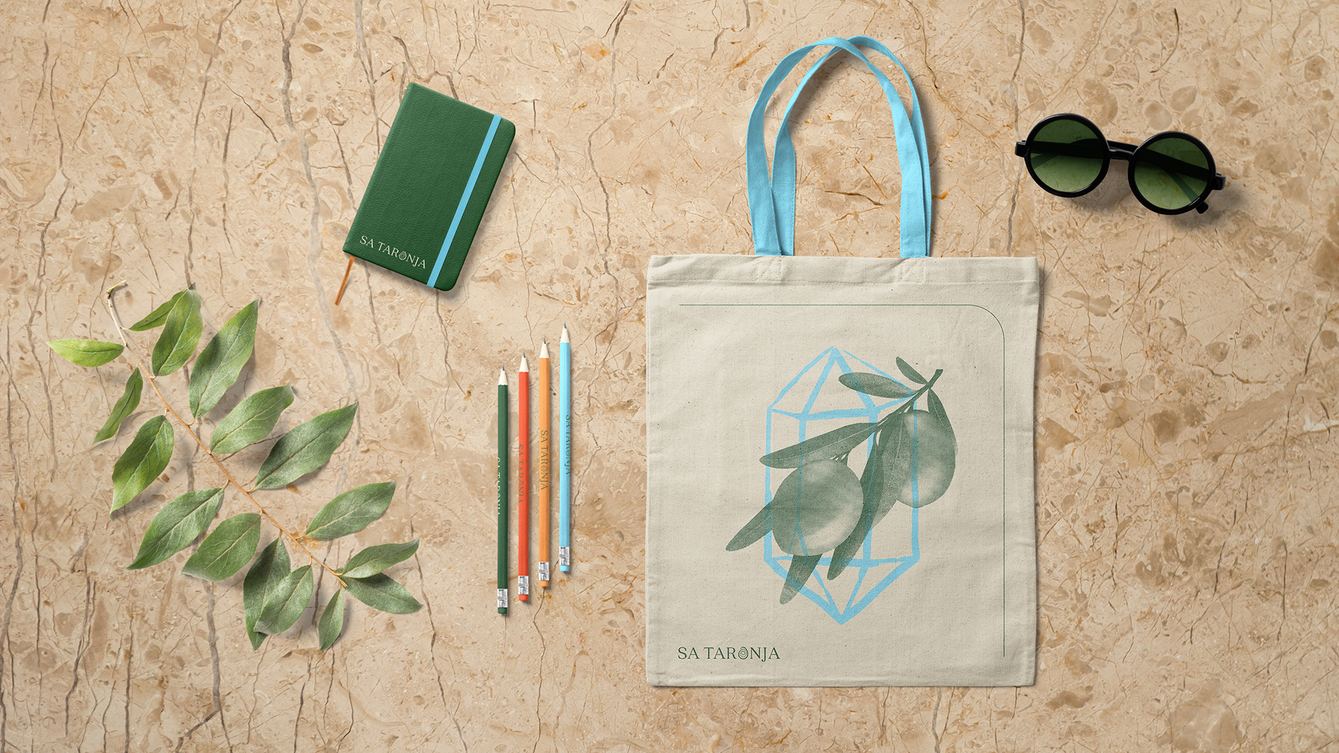 Sa Taronja tote bag, notepad and colorful pencils on lime stone background