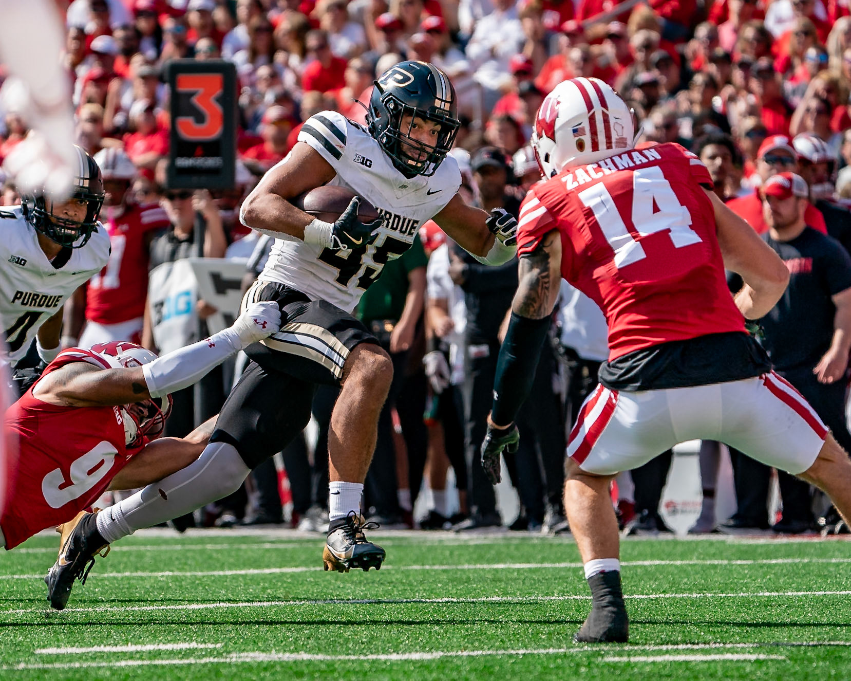 MADISON, WI - OCTOBER 5, 2024: Purdue University Junior Running Back Devin Mockobee (45) running after a pass catch while University of Wisconsin Junior S Austin Brown (9) and University of Wisconsin Redshirt Senior S Preston Zachman (14) try to tackle him during the Purdue University Boilermakers at University of Wisconsin Badger Football game at Camp Randall Stadium(Photo by Steve Bowen / NISports Report)