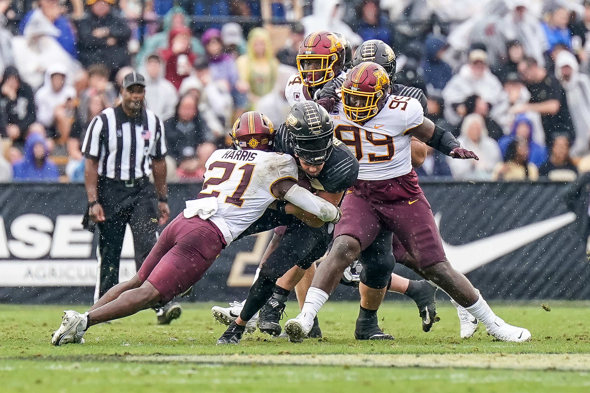 Purdue's Austin Burton (12) gets his helmet knocked off after a big tackle from Minnesota's Justus Harris (21)
