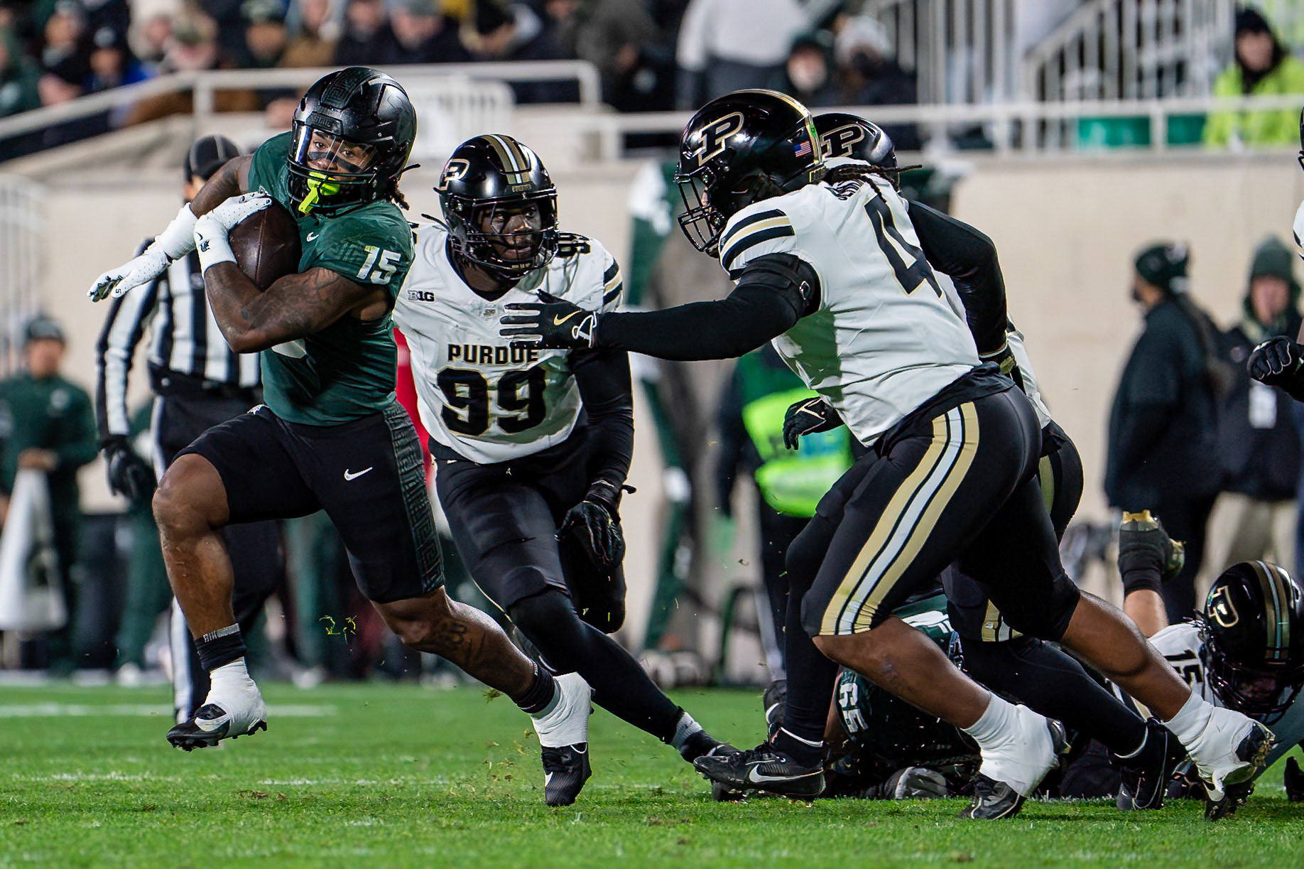 EAST LANSING, MI - NOVEMBER 22, 2024: Michigan State University Running Back Kay'ron Lynch-Adams (15) running away from Purdue University Senior Linebacker Kydran Jenkins (4) during the Purdue University Boilermakers at Michigan State University Spartans Football game at Spartan Stadium(Photo by Steve Bowen / Bowen Arrow Photography / Northern Indiana Sports Report)