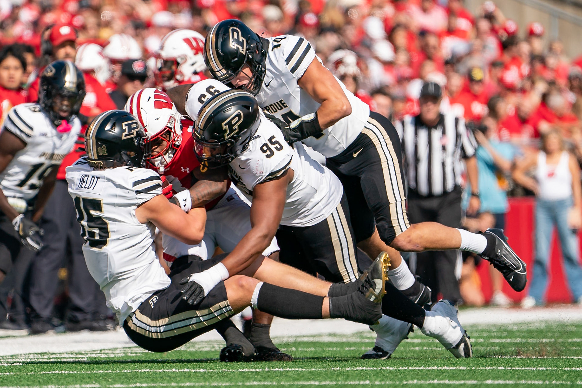 MADISON, WI - OCTOBER 5, 2024: Purdue University Sophomore Rush End Will Heldt (15), Purdue University Senior Defensive Lineman Joe Anderson (95) and Purdue University Junior Linebacker Yanni Karlaftis (14) tackling University of Wisconsin Senior RB Tawee Walker (3) during the Purdue University Boilermakers at University of Wisconsin Badger Football game at Camp Randall Stadium(Photo by Steve Bowen / NISports Report)