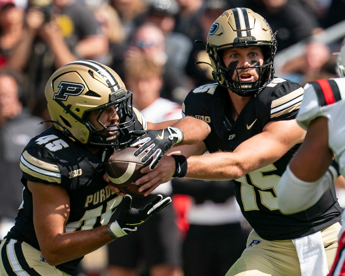 WEST LAFAYETTE, IN - AUGUST 30, 2025: Purdue University Sophomore Quaterback Ryan Browne (15) looking at the RPO options before handing off to Purdue University Senior Running Back Devin Mockobee (45) at Purdue Boilermaker Football vs Ball State Football at Ross-Ade Stadium(Photo by Steve Bowen / Northern Indiana Sports Report)