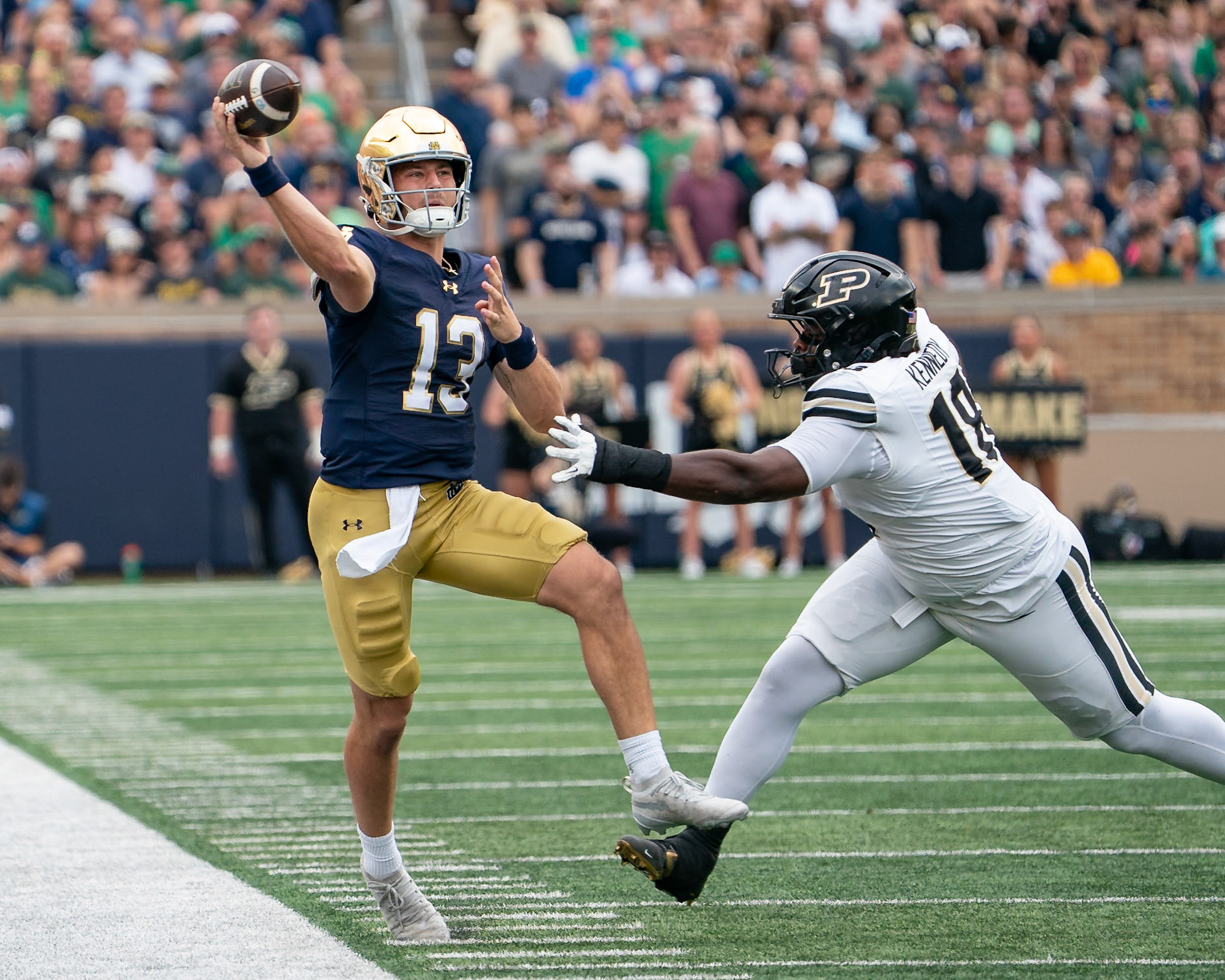 SOUTH BEND, IN - SEPTEMBER 20, 2025: Notre Dame University Freshman QB CJ Carr (13) throws a pass as he is being chased out of bounds but Purdue University's Sophomore Defensive Lineman Demeco Kennedy (18) in the Purdue Boilermakers at Notre Dame Fighting Irish Football at Notre Dame Stadium(Photo by Steve Bowen / Northern Indiana Sports Report)