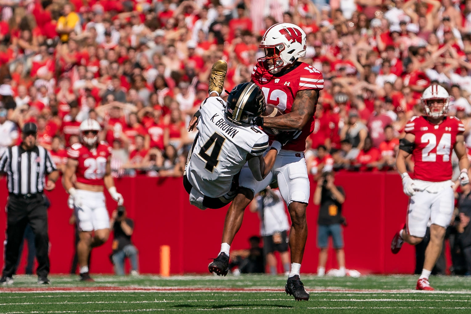MADISON, WI - OCTOBER 5, 2024: Purdue University Senior Wide Receiver Kam Brown (4) wrestling with University of Wisconsin Redshirt Senior CB Max Lofy (12) to catch a pass during the Purdue University Boilermakers at University of Wisconsin Badger Football game at Camp Randall Stadium(Photo by Steve Bowen / NISports Report)
