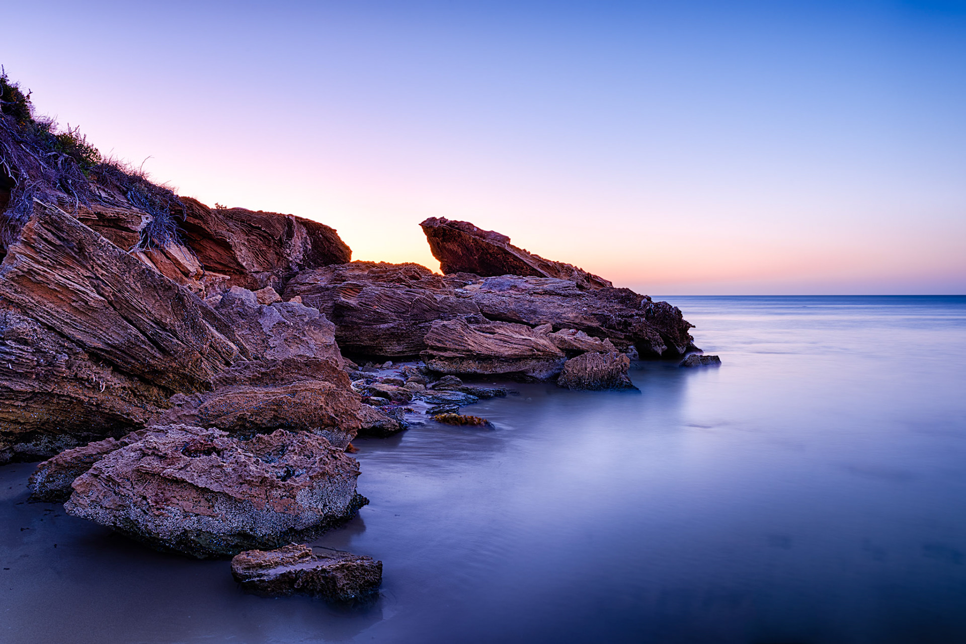 Title: Wright Bay, South Australia / Caption: The rugged rocks and cliffs along this part of the Limestone Coast in South Australia contrast well with the calm sea at low tode in this long exposure shot of the coastline.