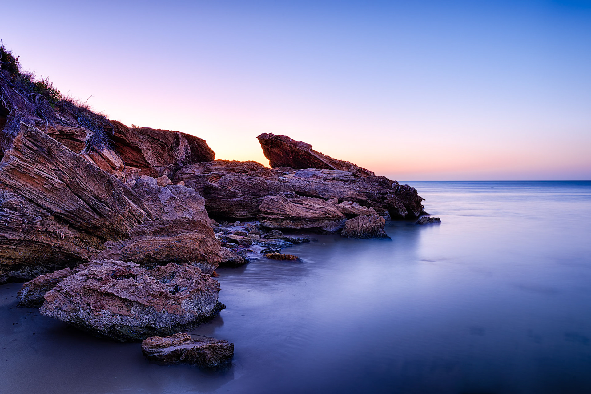 Title: Wright Bay, South Australia / Caption: The rugged rocks and cliffs along this part of the Limestone Coast in South Australia contrast well with the calm sea at low tode in this long exposure shot of the coastline.