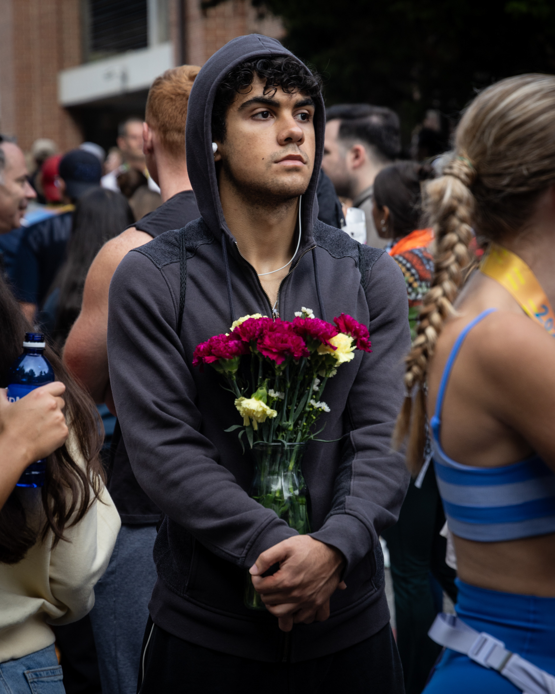A spectator holds flowers at the finish line of the AthHalf half marathon in Athens, Georgia on Sunday, Oct. 12, 2025. AthHalf is a fundraiser for Athfest Educates, which awards grants to schools, nonprofits and government agencies. (Photo/Emily Laycock)