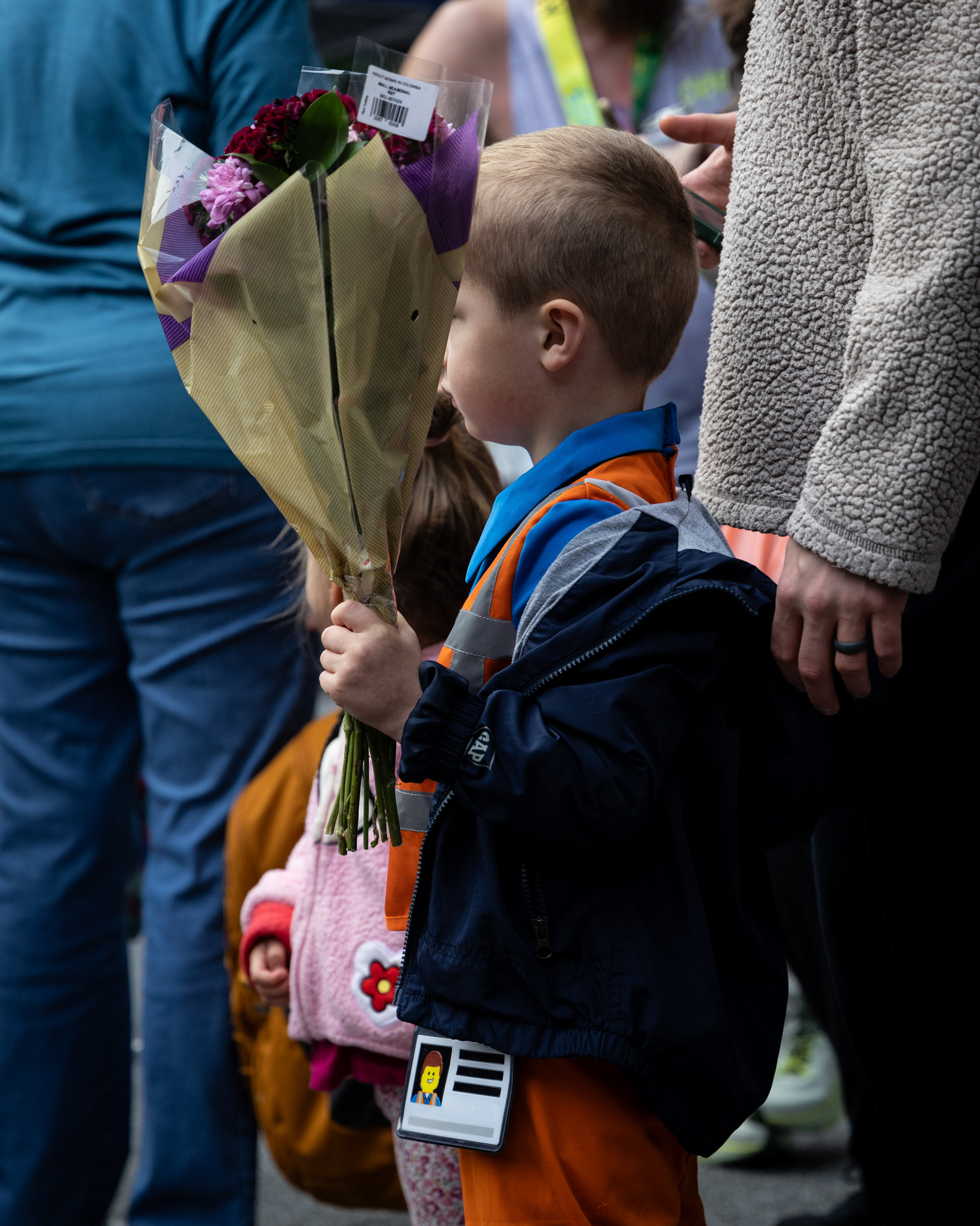 A spectator holds flowers at the finish line of the AthHalf half marathon in Athens, Georgia on Sunday, Oct. 12, 2025. AthHalf is a fundraiser for Athfest Educates, which awards grants to schools, nonprofits and government agencies. (Photo/Emily Laycock)