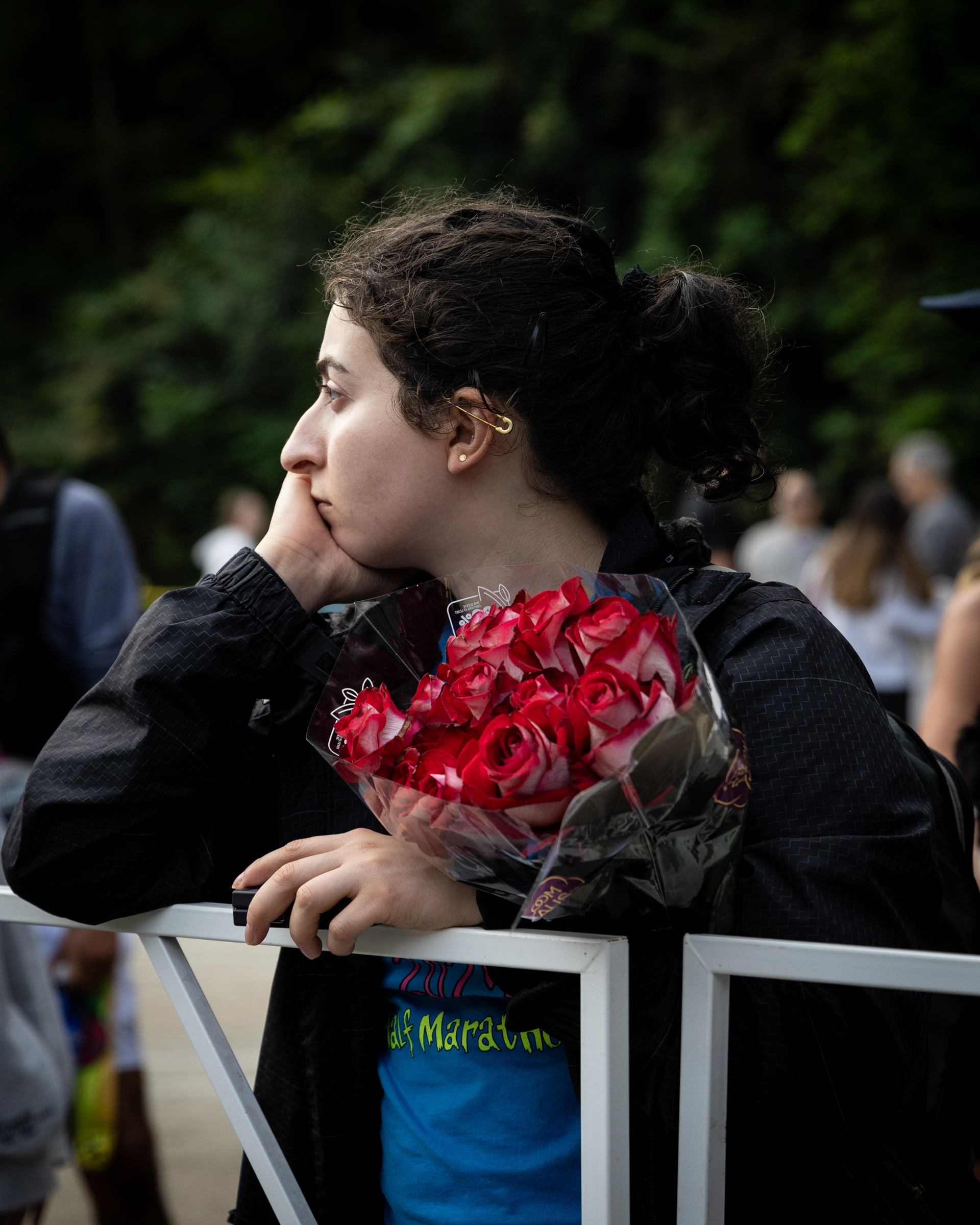 A spectator holds flowers at the finish line of the AthHalf half marathon in Athens, Georgia on Sunday, Oct. 12, 2025. AthHalf is a fundraiser for Athfest Educates, which awards grants to schools, nonprofits and government agencies. (Photo/Emily Laycock)