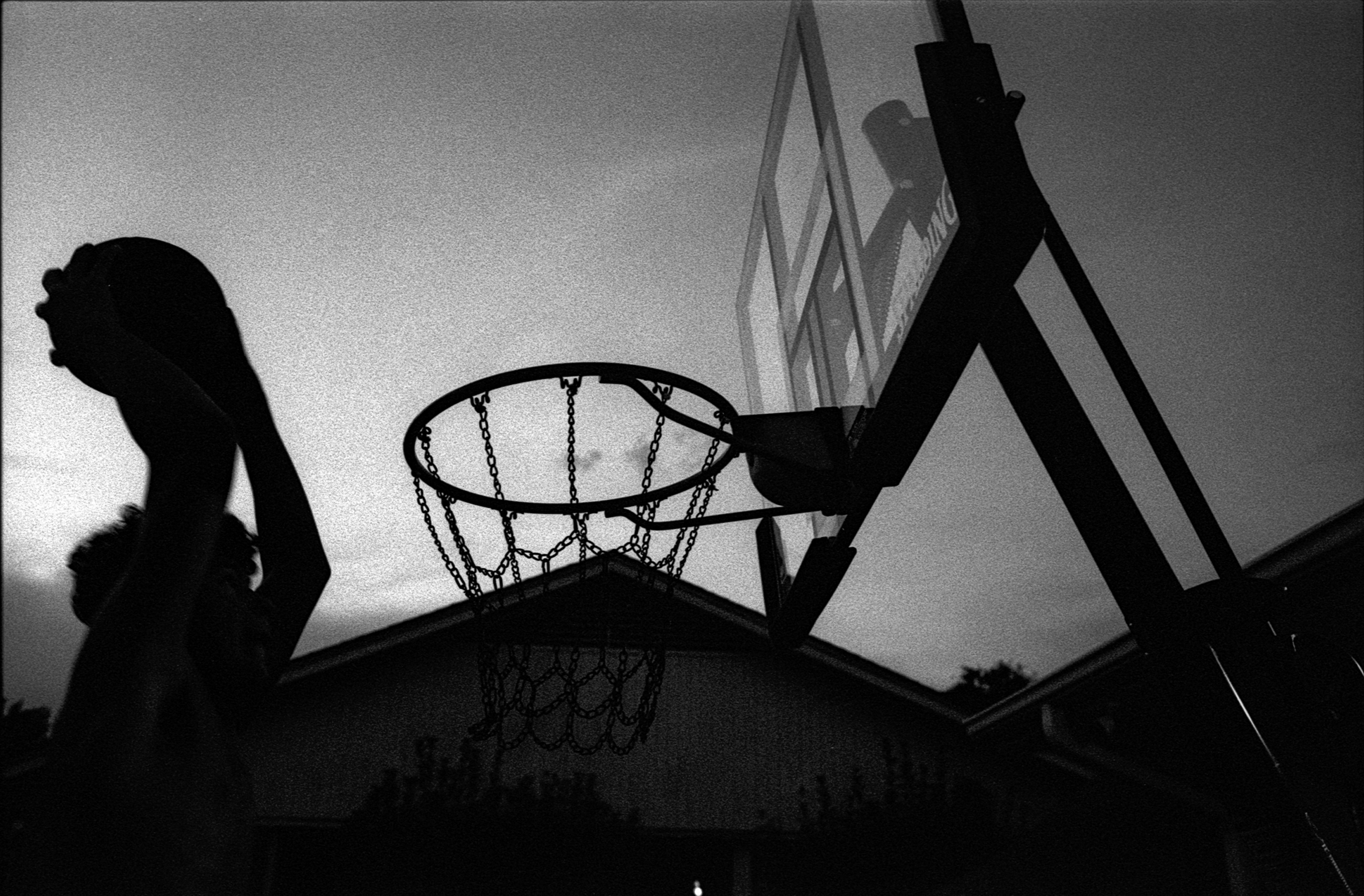 My brother dunks a basketball on our home goal.