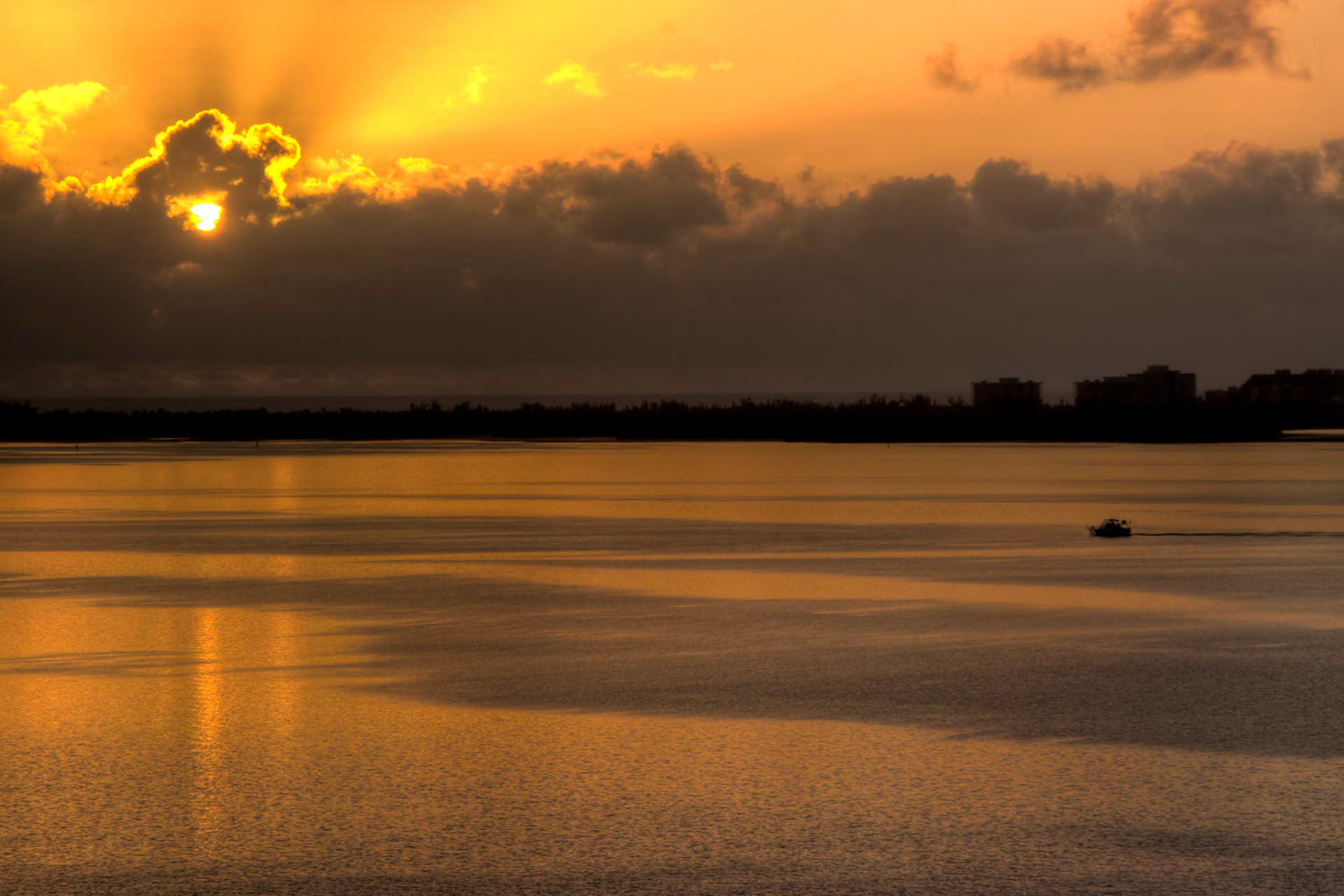 A fishing boat returning from the Atlantic Ocean, passing by Key Biscayne, Florida at sunrise.