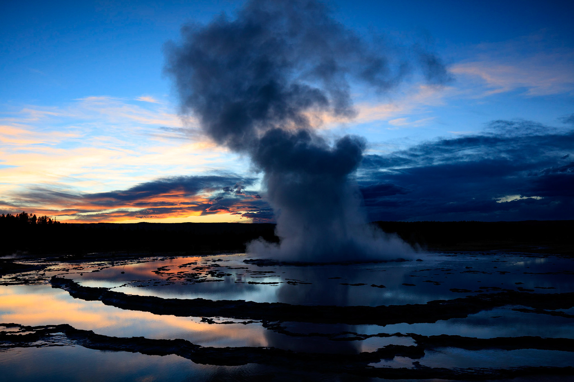 The Great Fountain on Firehole Lake Drive in Yellowstone National Park, illuminated by the setting sun.