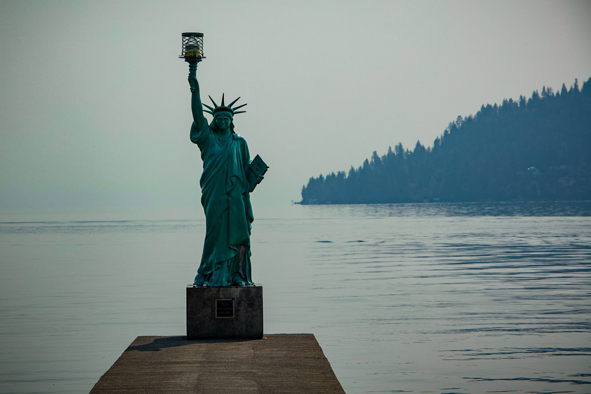 A replica Statue of Liberty stading at the end of a pier that juts out into Lake Pend Oreille
in Sandpoint, Idaho. The statue can be found in Sandpoint City Beach Park.