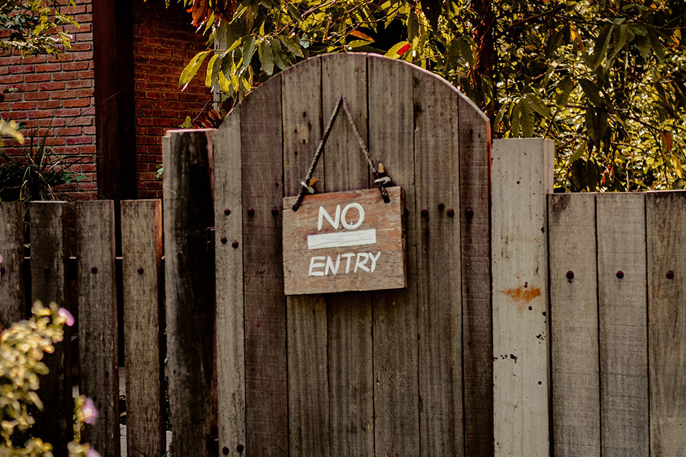 A wooden "No Entry" sign hung on a wooden fence to show that Celeste Polley don't work for free.
