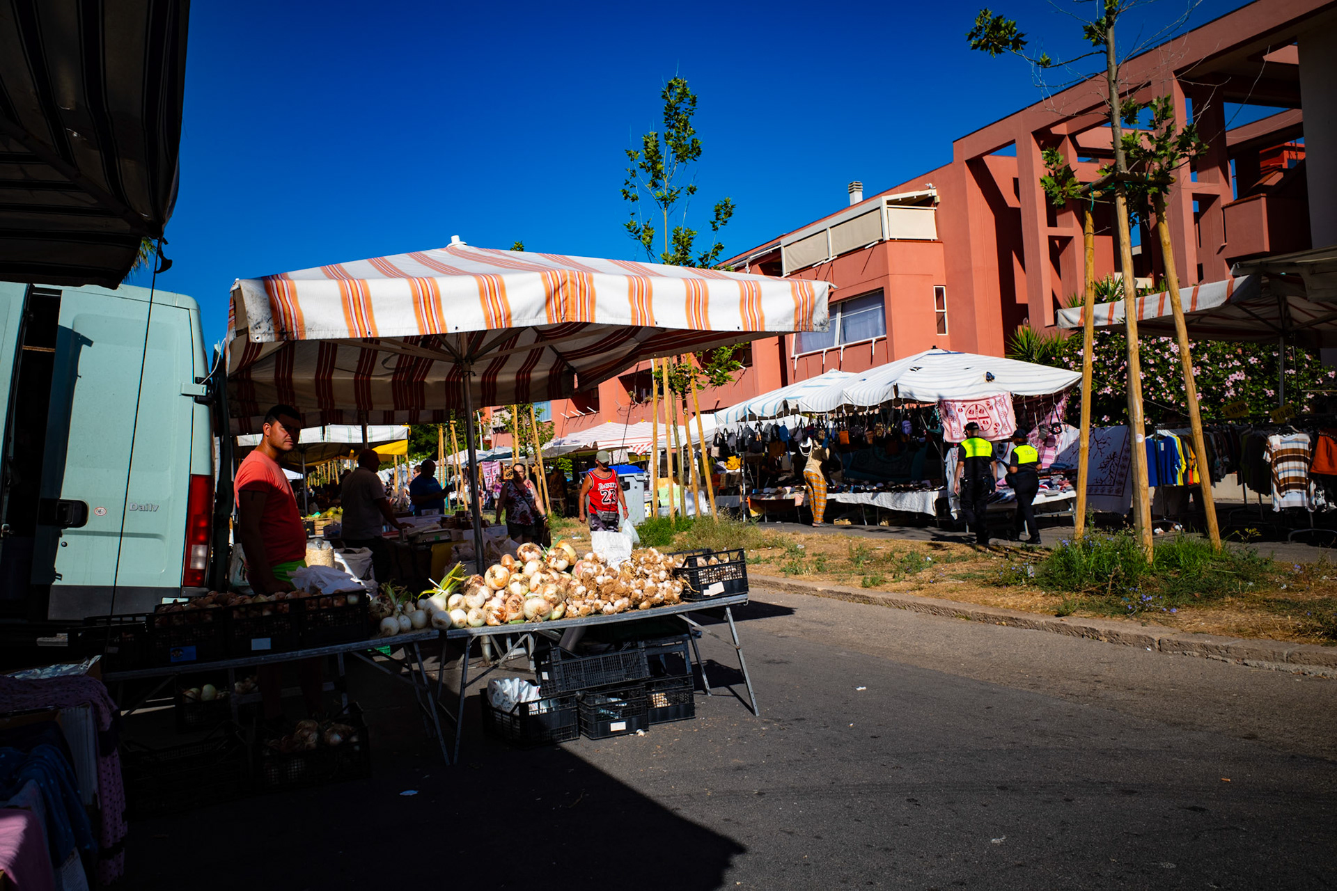 Onions and sun under striped tents