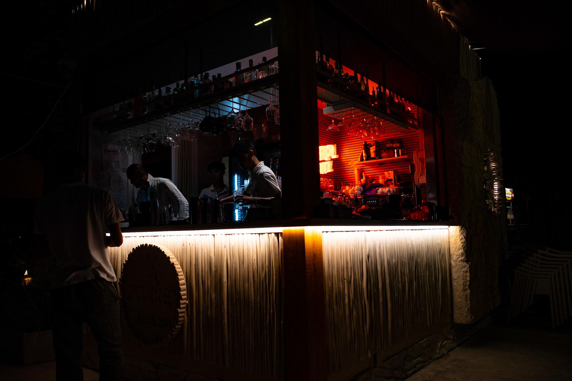 Where neon whispers and ice clinks