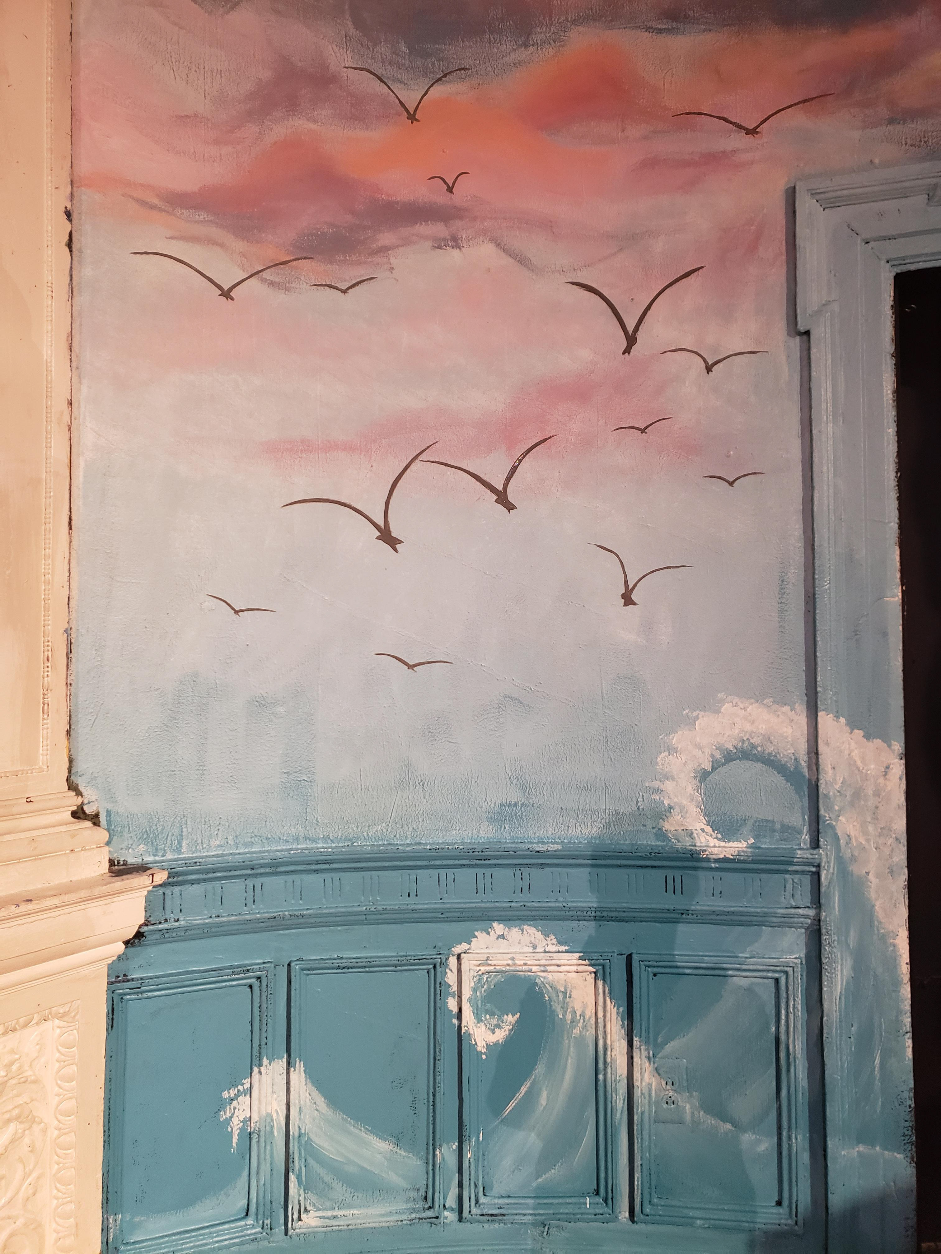 The seagulls, ocean, and clouds.