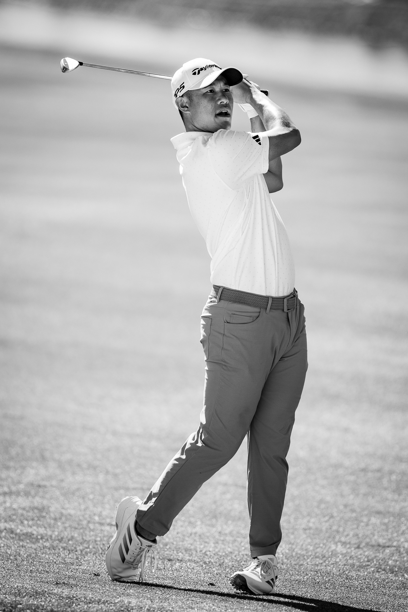 Collin Morikawa watches his approach shot from the fairway on the par-4 18th hole during the second round of the WM Phoenix Open at TPC Scottsdale. Collin is one of my favorite players on tour to watch. So I knew that he was someone that I wanted to get a few photos of during his time at the WM. He was in the middle of the fairway on the 18th hole when I noticed the outfit that he was wearing for the day. It was something that was super contrasty. The white shirt with his darker tan pants really came out well after converting my photo to black and white. I really like the balance as well as emotion that he has on his face as he is watching his second shot. Taken on the Canon EF 300mm f/2.8. February 7, 2026.