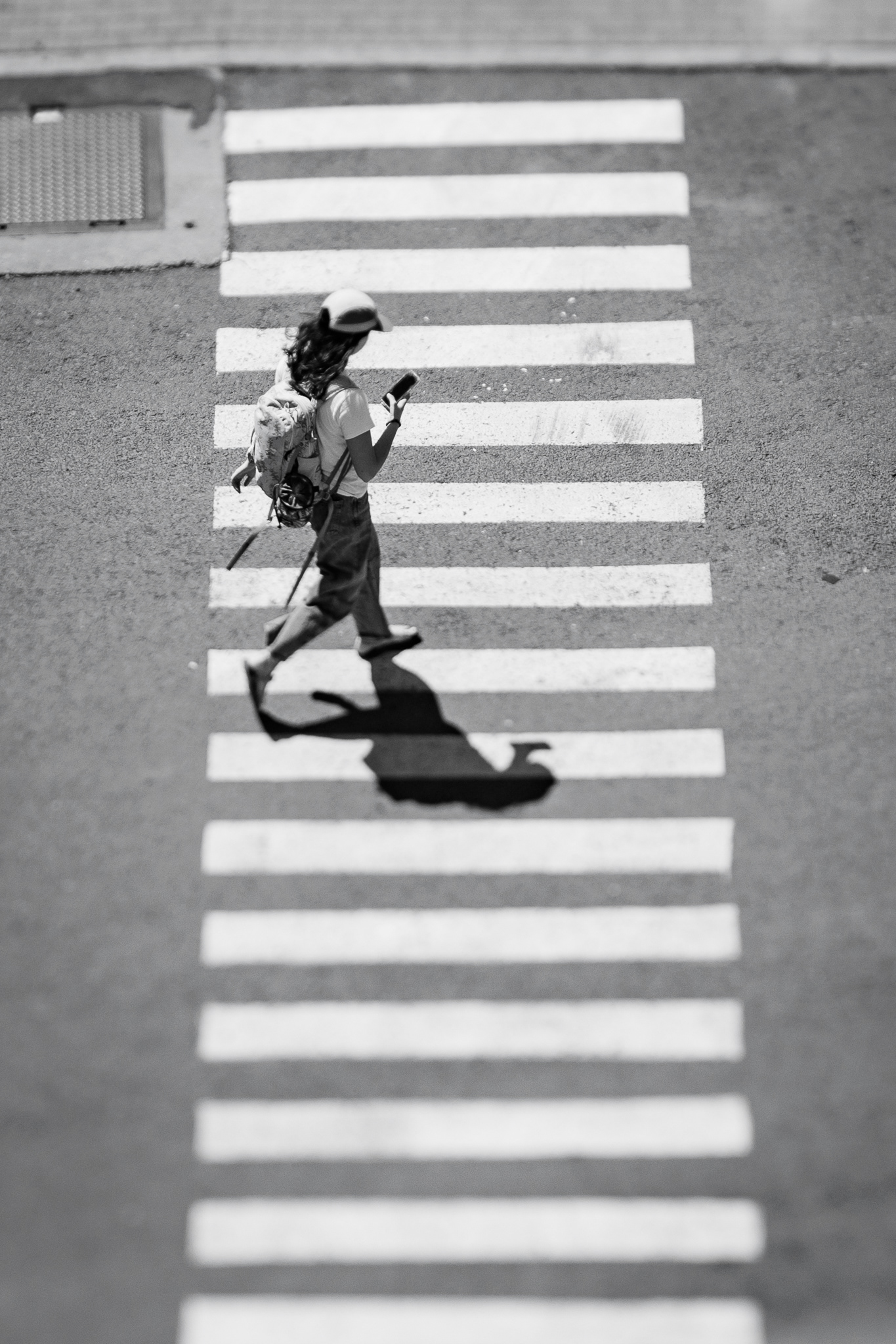 An NAU student crosses a sidewalk outside of the San Francisco Parking Garage. Tilt shift lenses have always been something that I have wanted to experiment with for the longest time. So I think that it would be a really fun idea to make everyone look like they are action figures. I had tried previously for this, and it didn't go the way that I thought it would go. Everything started off super soft, which was kinda frustrating. But I kept trying the idea again, and was so happy that I did. I was waiting for my decisive moment, and I finally got one. I loved the placement of the shadows and the whites of the sidewalk. Taken on the Canon EF 90mm Tilt Shift Lens f/2.8. April 7, 2026.  