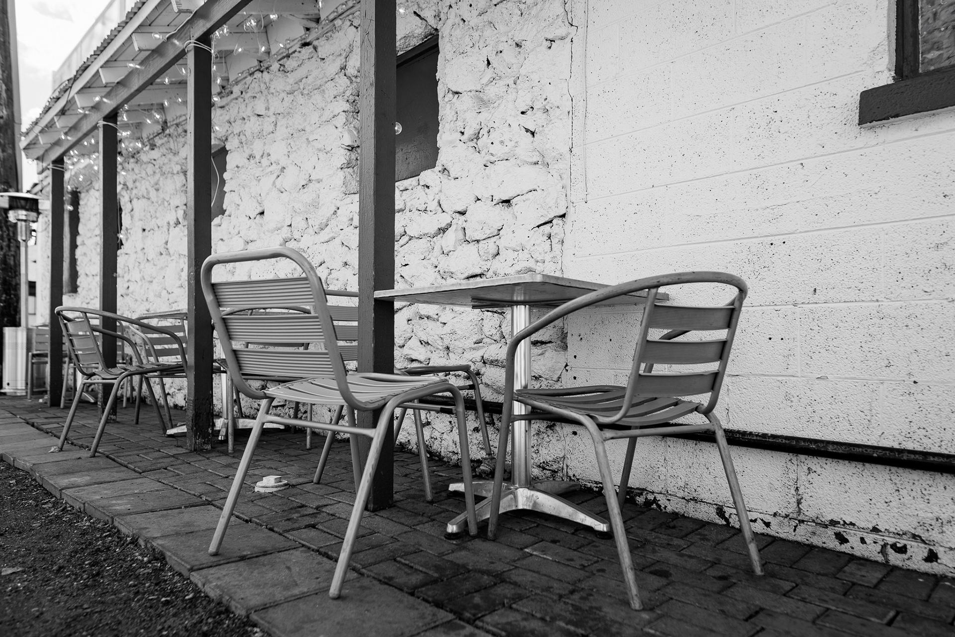 A set of tables and chairs sits outside of Evan's Fish and Chips on a cloudy day. This was one of the photos that I tried to take when taking a specific focus on simplicity. And I really liked the mini story that I was able to tell. Just the chairs sitting there. As well as a sense of history of Evan's too. With the texture from not only the chairs but also from the brick in the background.  It told a really vast story that I really think was done super well because of my lens choice here. Taken on the Sigma 20mm f/1.4 Art Lens.  March 5, 2026.