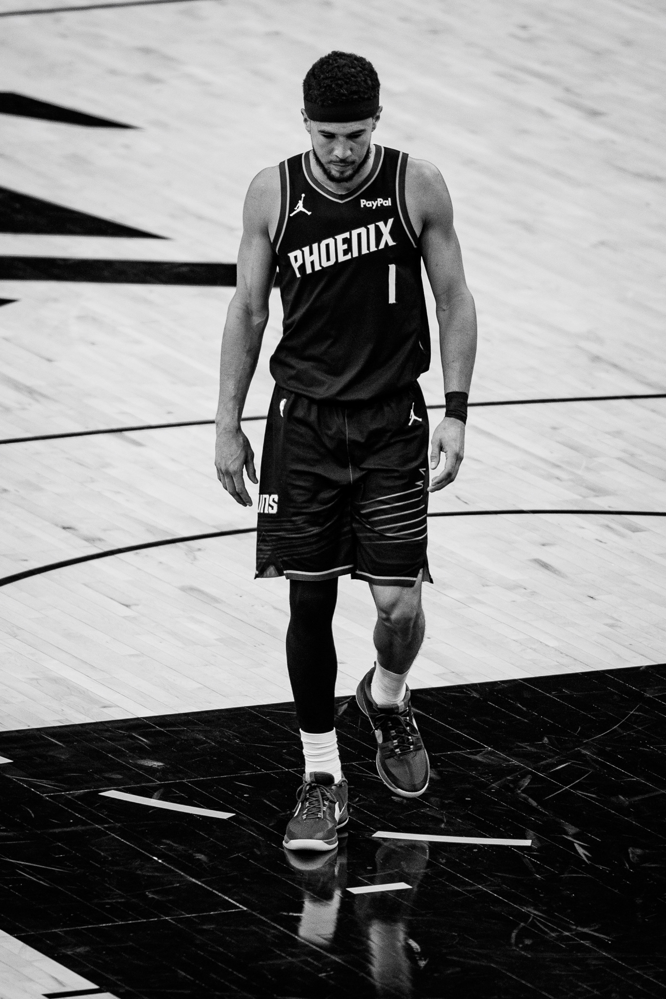 Phoenix Suns shooting guard Devin Booker (1) walks on to the court during the western conference play in game against the Portland Trail Blazers. This game was honestly one that was made to be shot in black and white. Their jerseys were super sharp and the court also had black lettering to correspond with the white color of the court. I also really love the reflection here to help create depth to the image and really tie it together. Taken on Canon EF 300mm f/2.8. Taken on April 14, 2026.