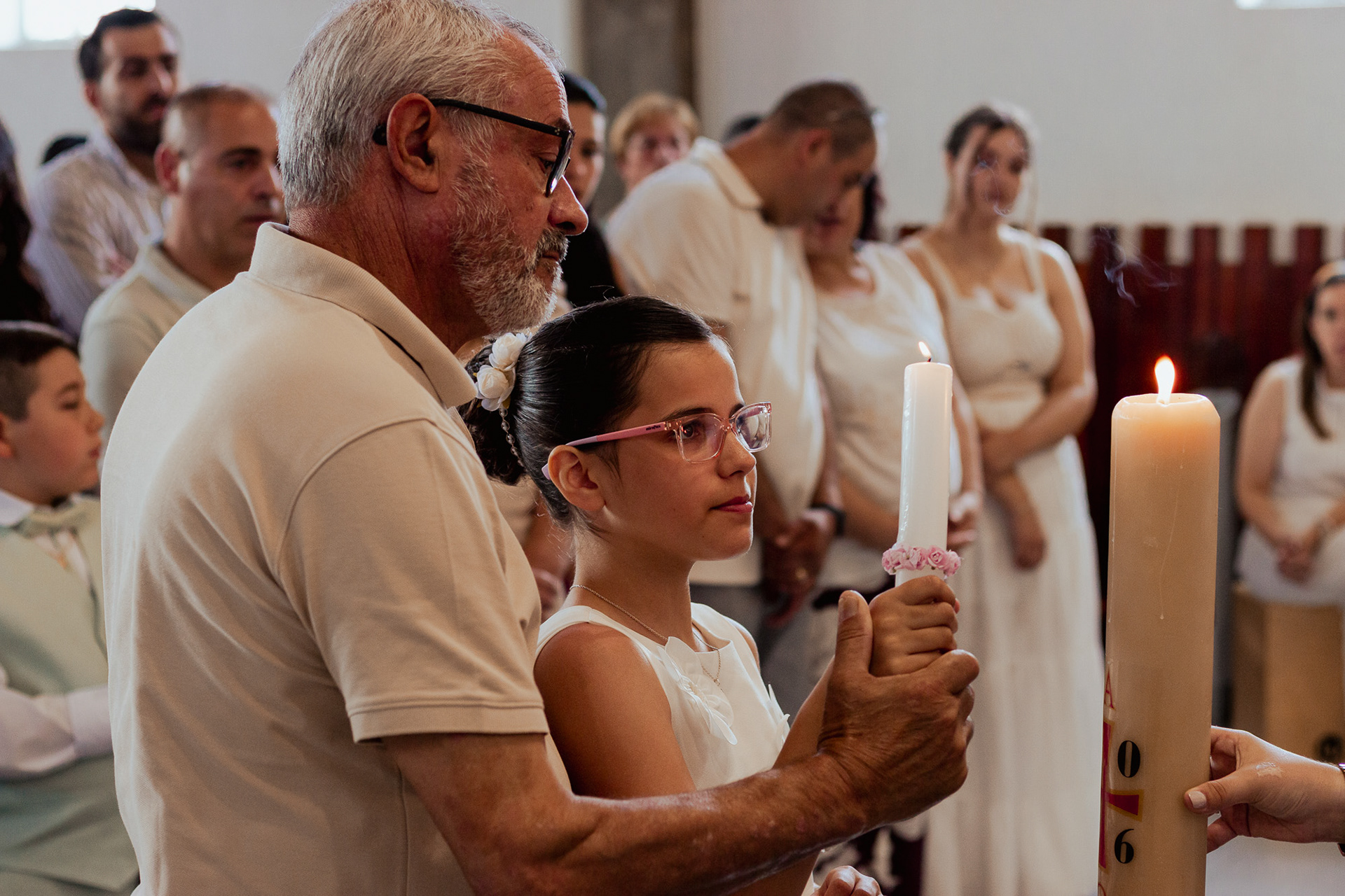 Retrato de menino/menina com a vela de comunhão na igreja, fotografia por Lara Peixoto.