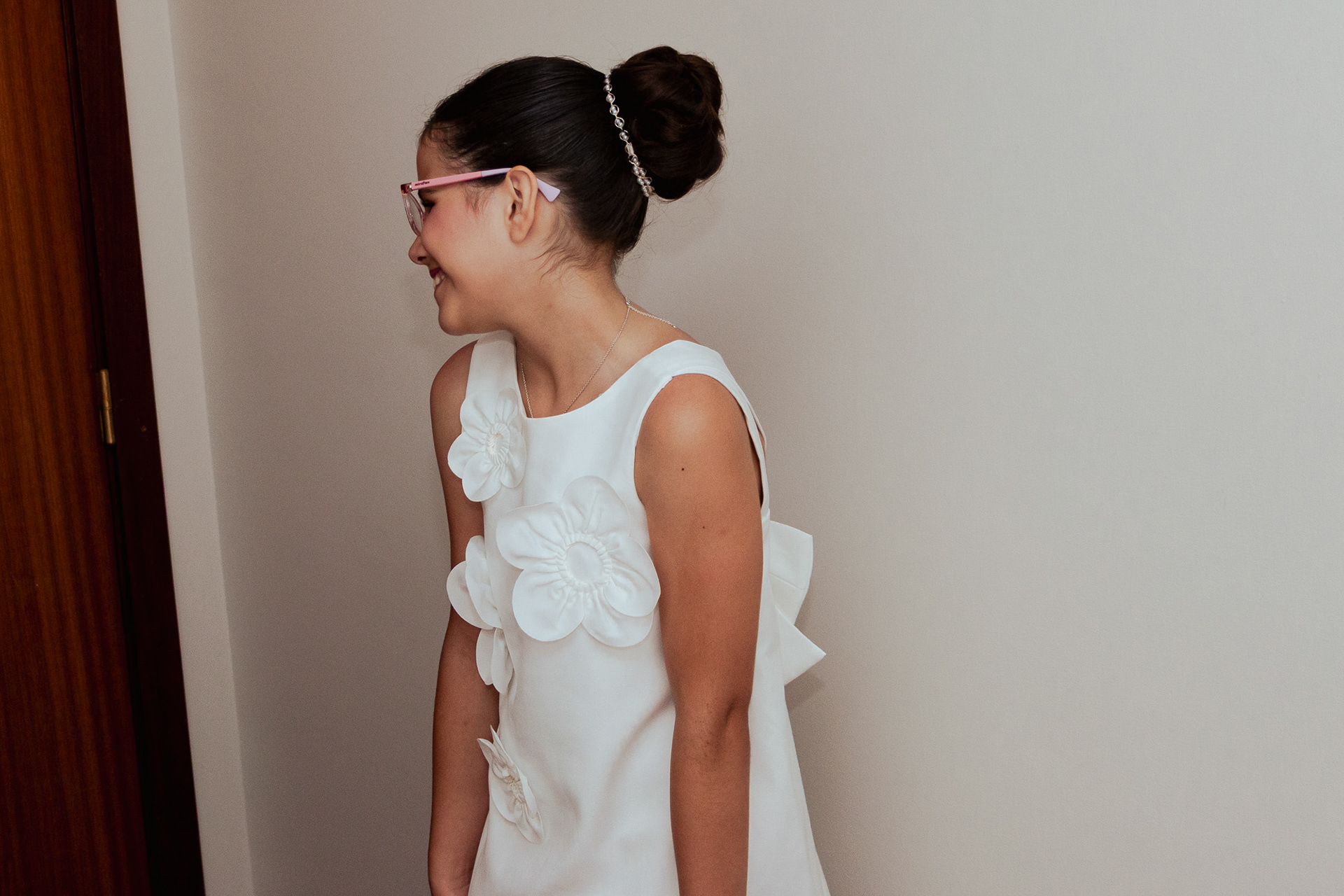 Mãe a ajudar a filha a vestir o vestido de comunhão em casa, fotografia por Lara Peixoto.