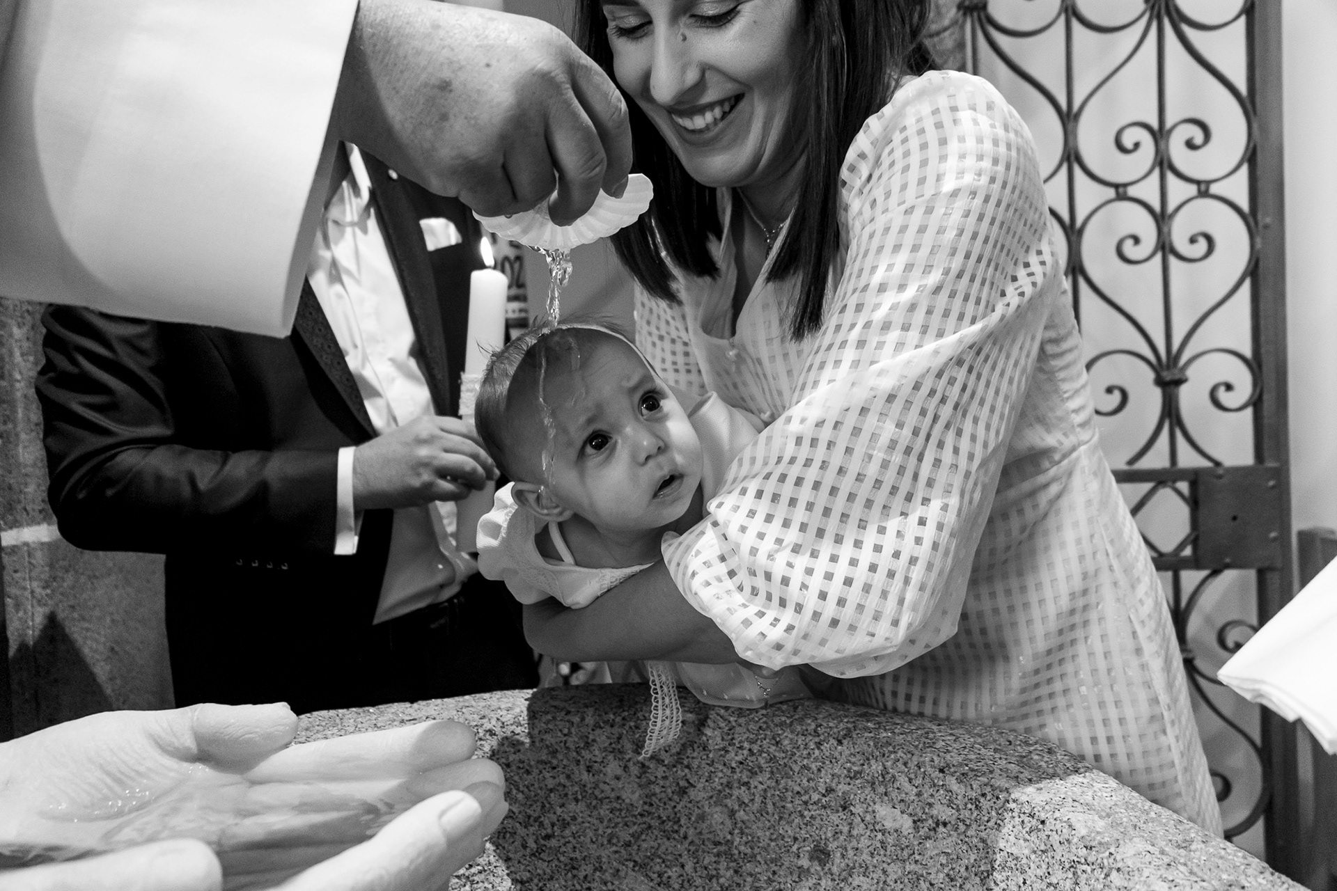Momento do batismo com água na pia batismal, fotografia de batizado no Porto por Lara Peixoto Photography