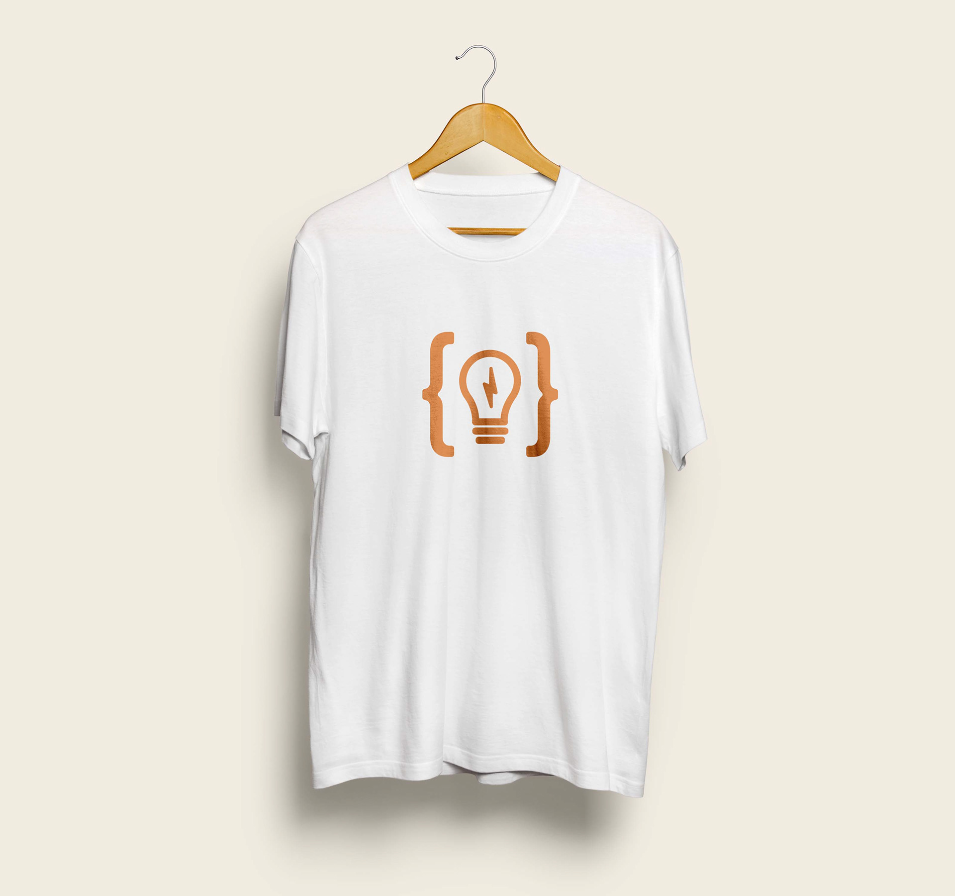 En vit t-shirt med tryck hänger på en galge