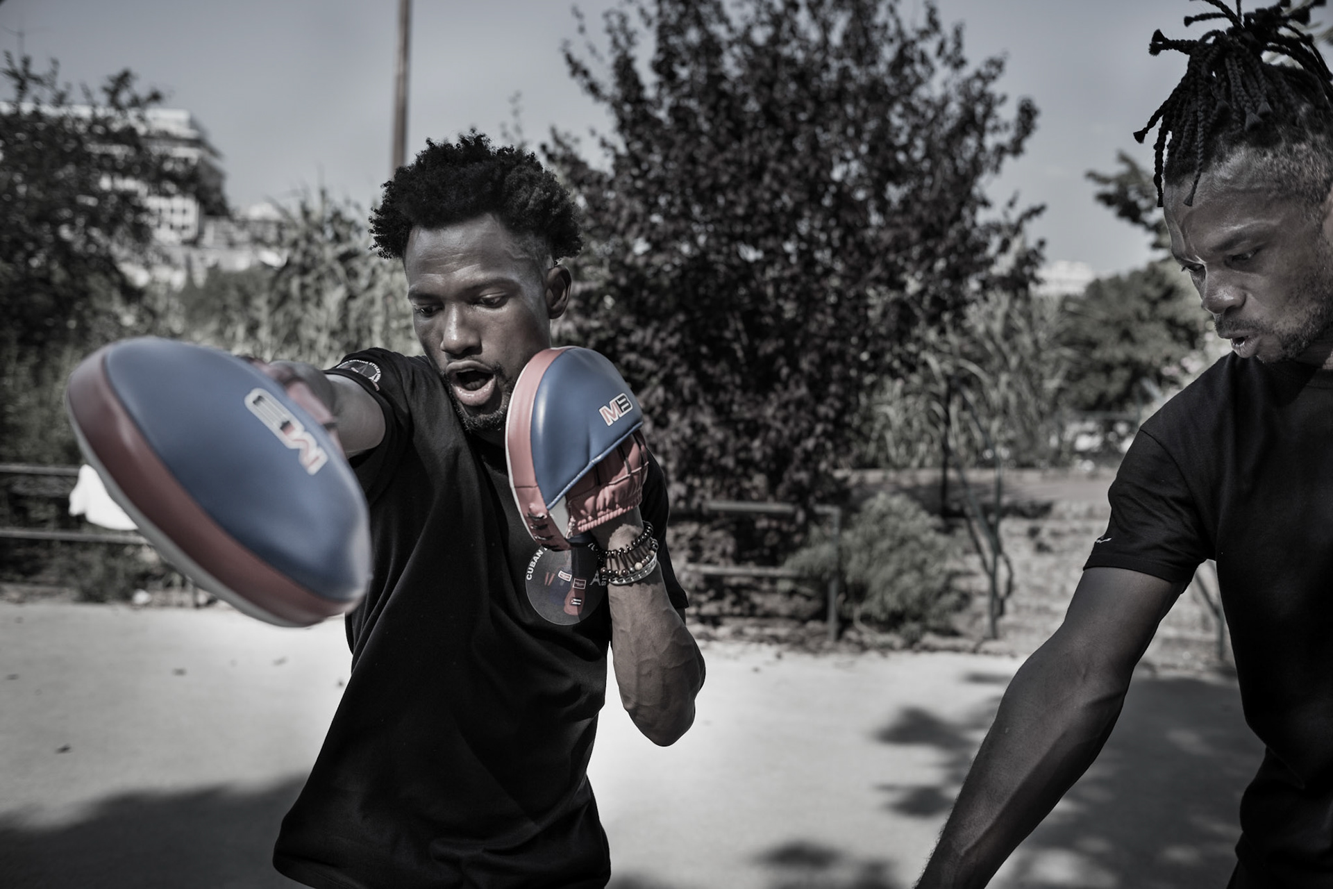 Two amateur boxers working on their boxing skills in a public park in Paris, France.