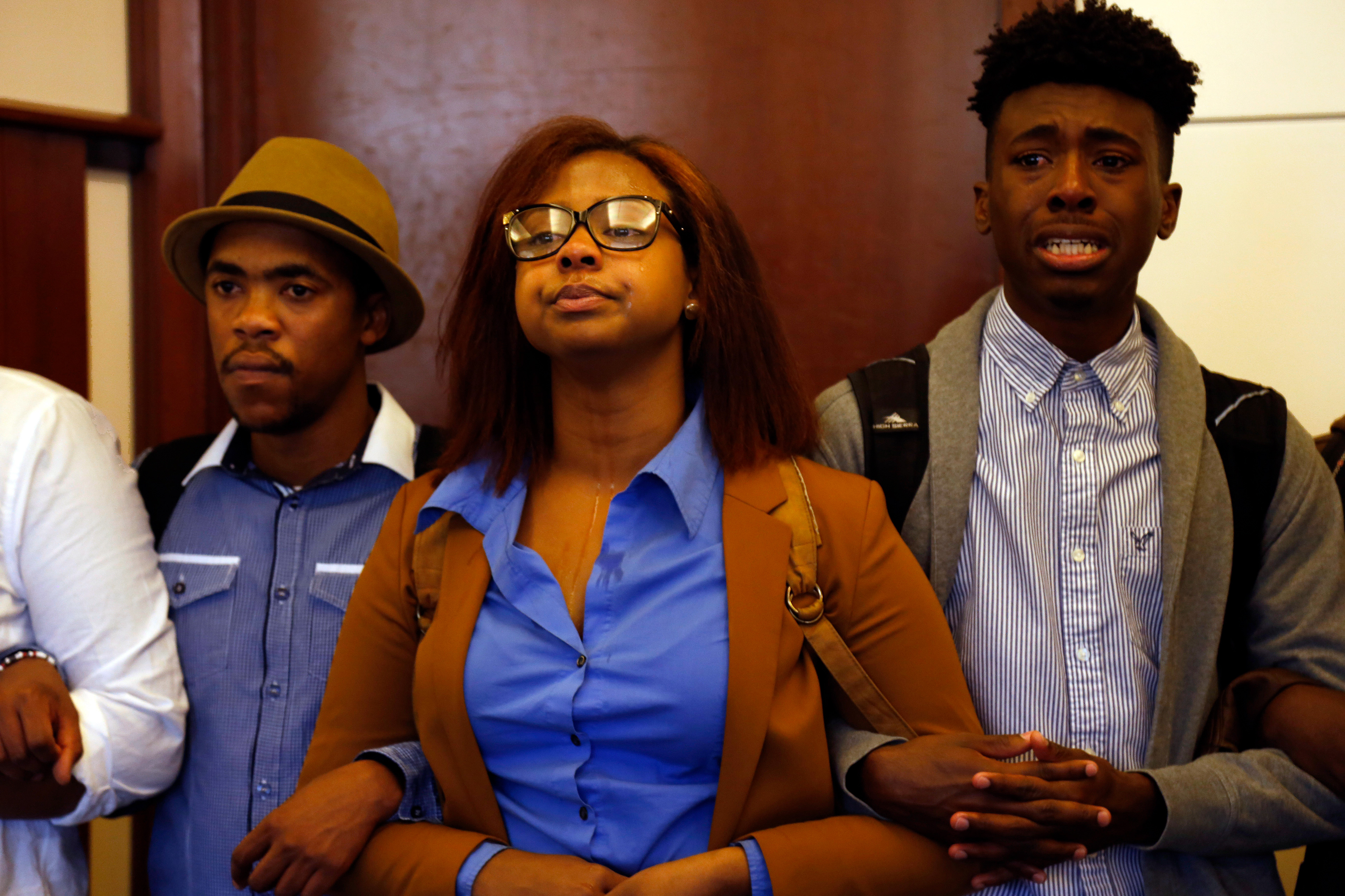 Members of Concerned Student 1950 lock arms while others share personal accounts of racism on campus at the Alumni Center on Saturday, Nov. 7, 2015. The Alumni Center was the last destination for the protest and ended in tears, prayer and hugs outside the building.