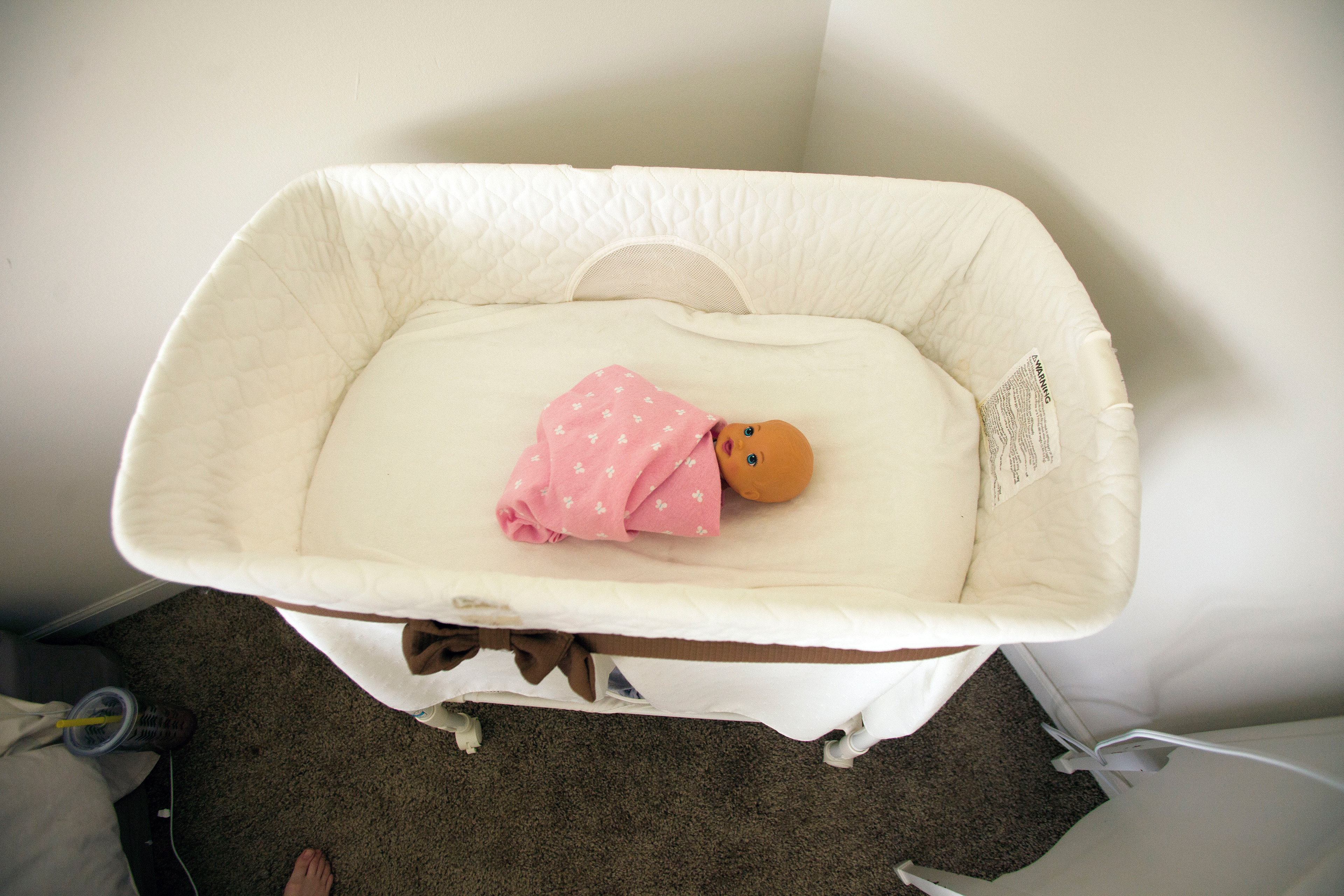 A toy baby doll lies in a basinet on Sunday, April 24, 2016. Haylie Payne, 8, is practicing how to take care of a baby so that she is prepared when her little sister is born.