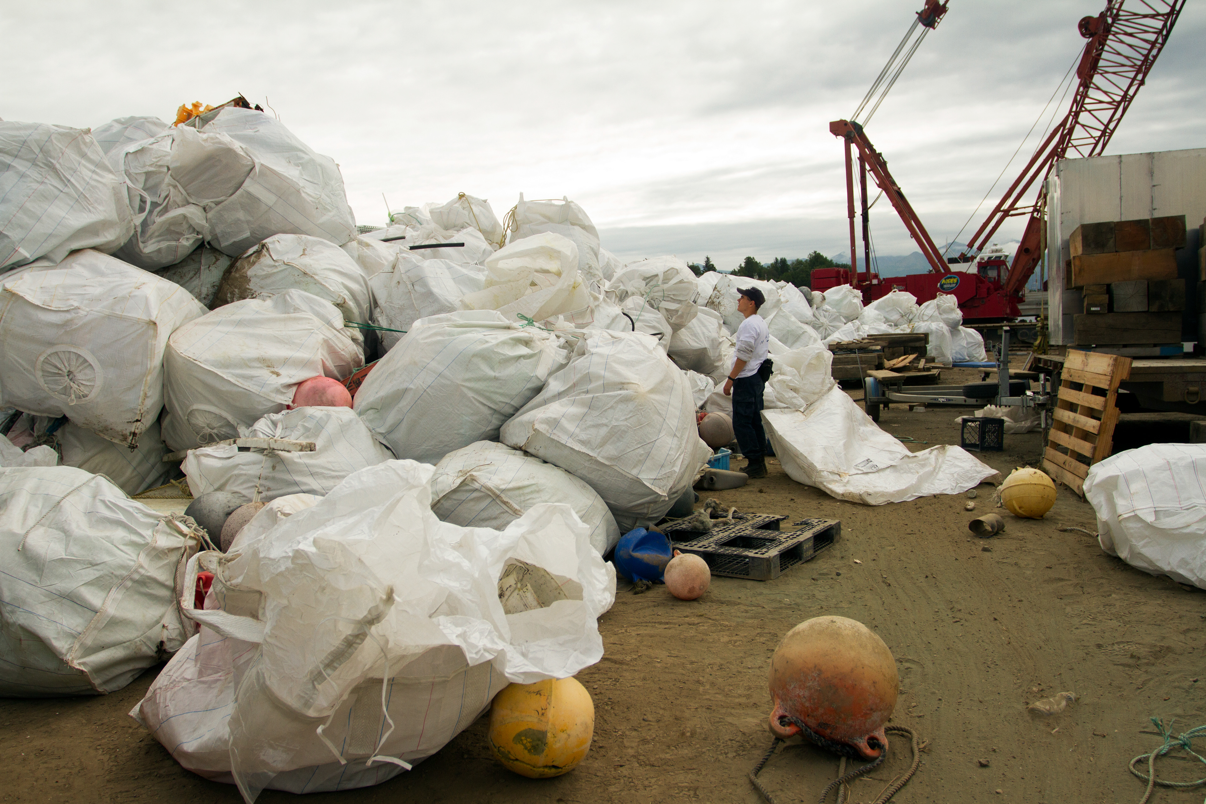 Alek Hanson searches for interesting finds among the piles of debris from the Pacific Ocean during the Great Alaska Marine Debris Sorting Project at the Port of Anchorage on Saturday, July 16, 2016. Hanson came with 58 members from the Alaska Military Youth Academy to volunteer.