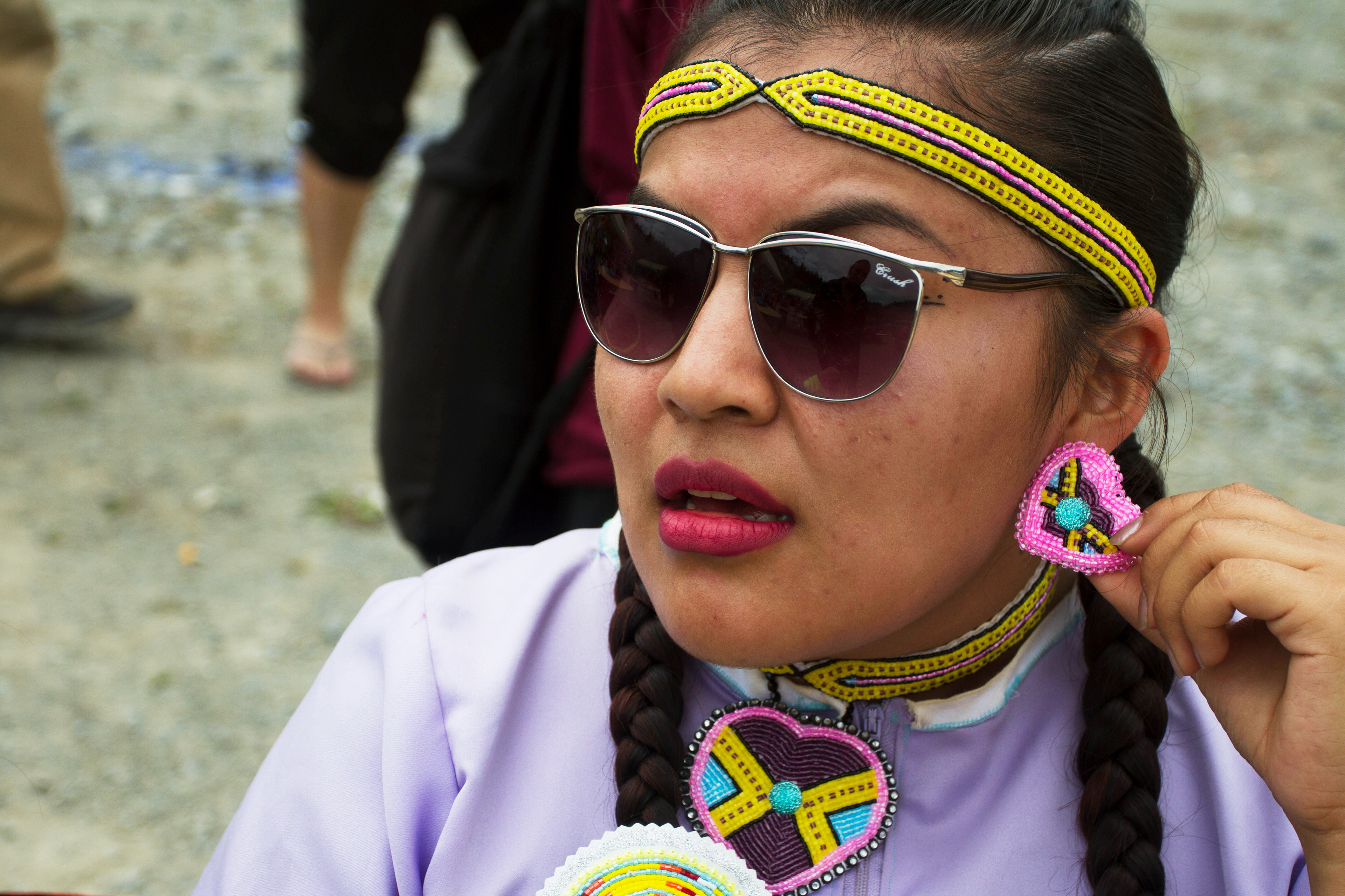 Katrina Deacon, 19, rests after dancing during the Eklutna Pow-wow on Saturday, June 18, 2016. 