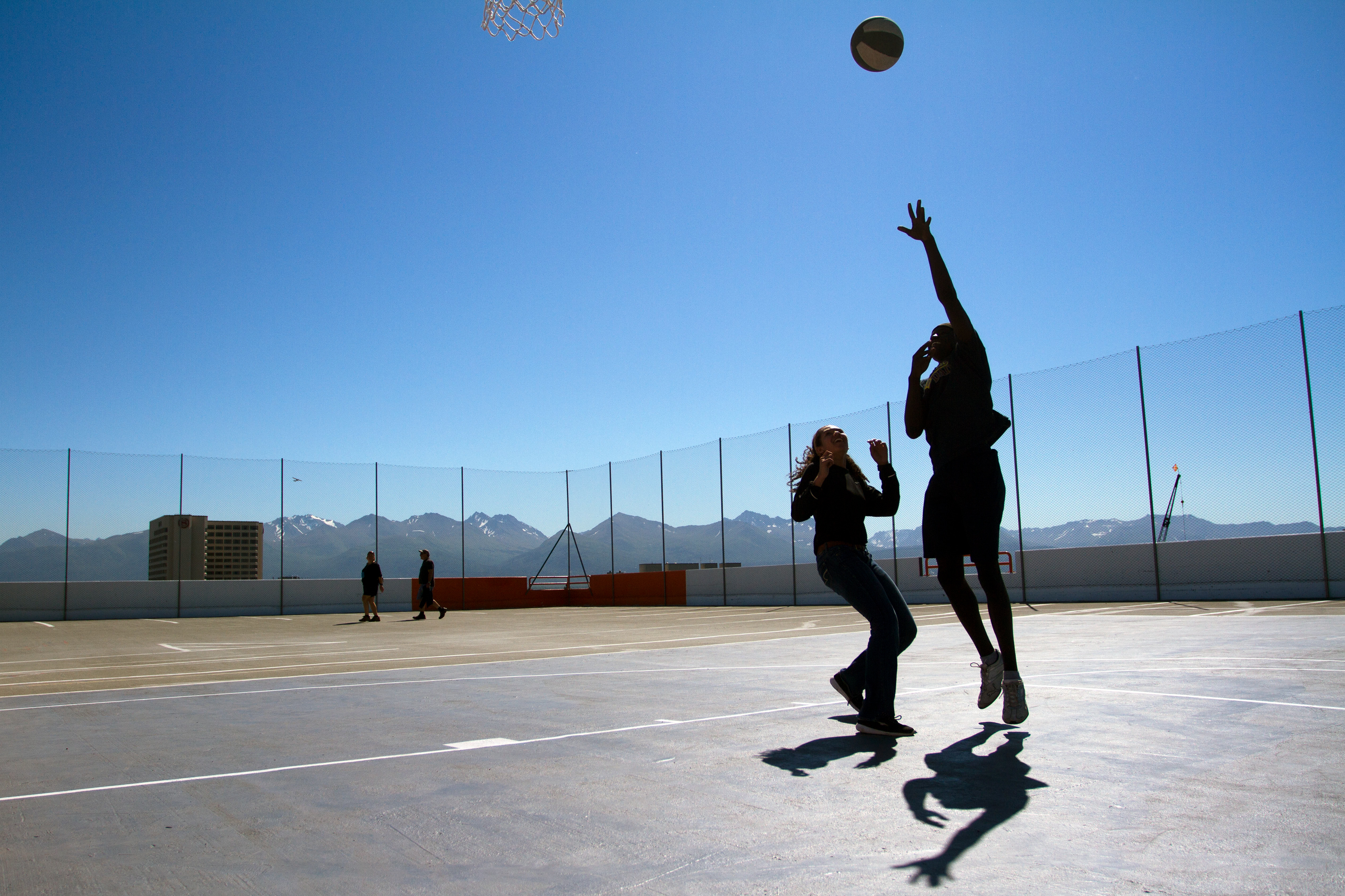 Ayuel Dak, 16, shoots the ball while playing basketball with Jaxx Whitney, 15, at The Rooftop on Thursday, June 16, 2016. The new park includes half court basketball, table tennis, chess, and seating located on the top floor of the 5th Avenue Garage.