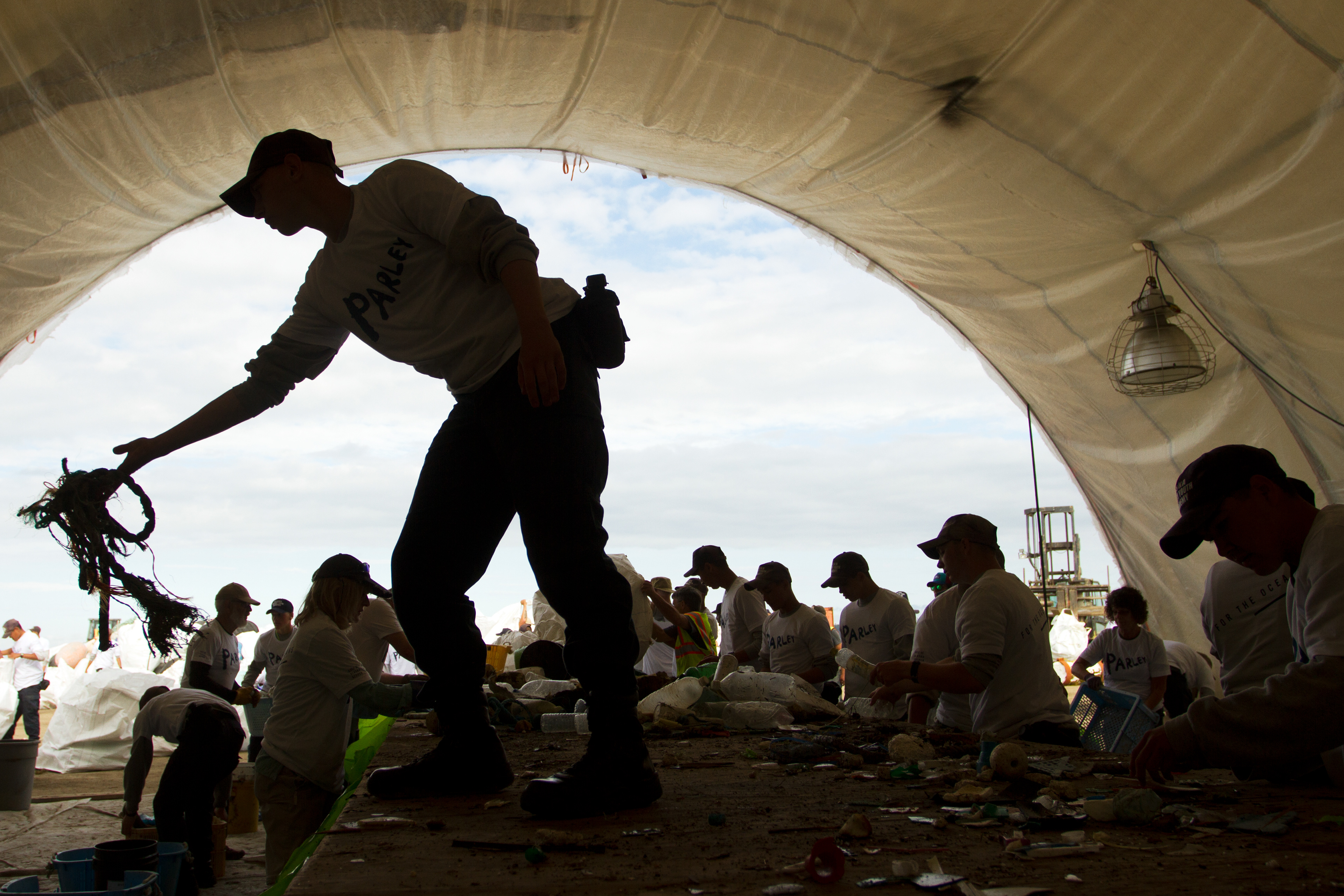 Jacob Endicott tosses rope into a pile while sorting debris found in the Pacific Ocean during the Great Alaska Marine Debris Sorting Project at the Port of Anchorage on Saturday, July 16, 2016. Volunteers sorted plastics, netting and buoys.