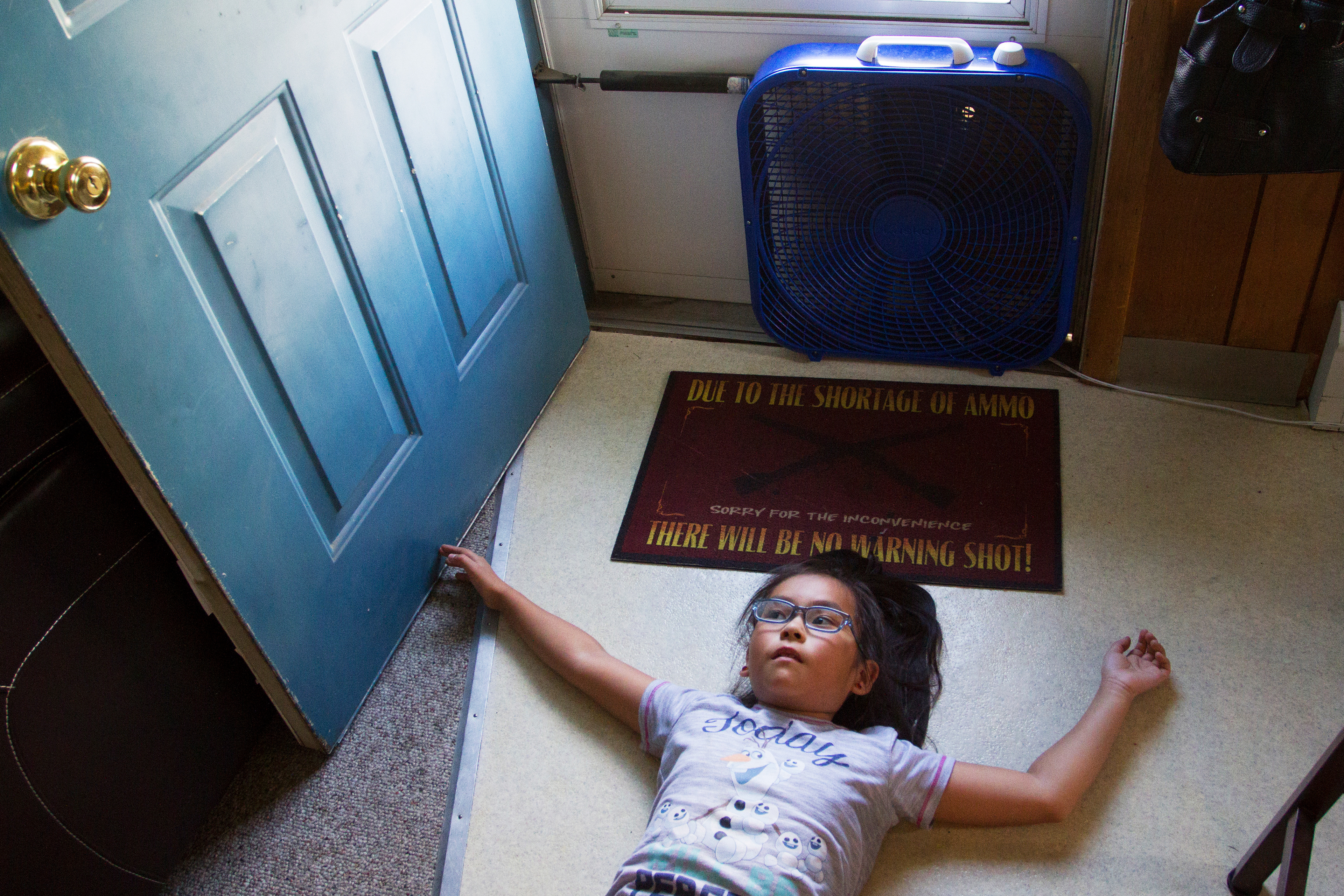 Sierra Balluta, 8, lies on the ground in front of a fan in her home in Anchorage on Monday, June 13, 2016. Balluta is this year's Tebughna Foundation Ida'ina Friendship Gathering Pow-wow princess, which took place in April.