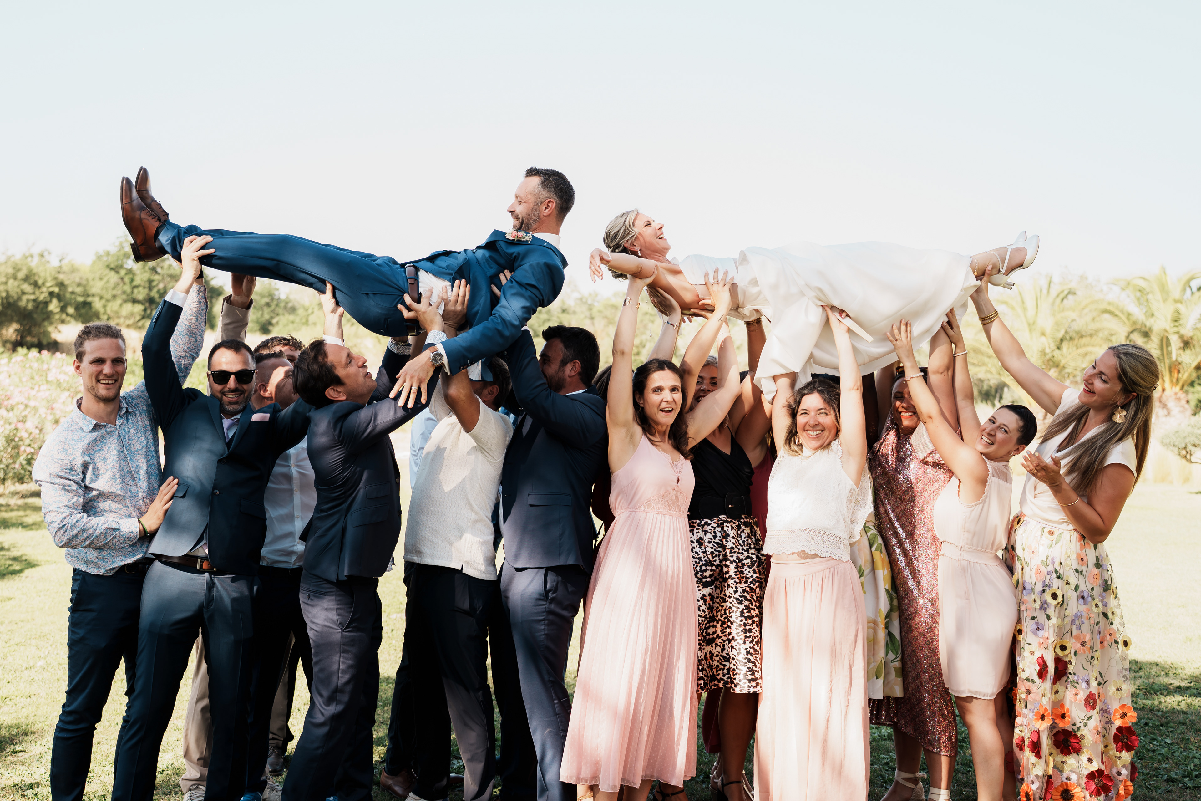 Les demoiselles et garçons d’honneur portent les mariés à bout de bras lors du mariage dans l’Hérault
