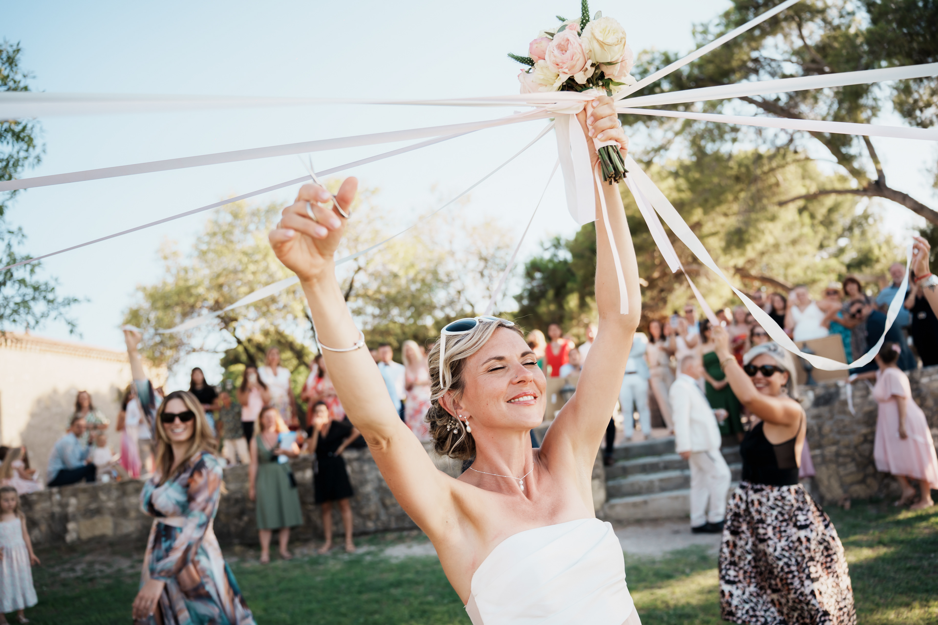 Jeu de la ronde des rubans avec la mariée les yeux fermés pendant la réception de mariage dans l’Hérault