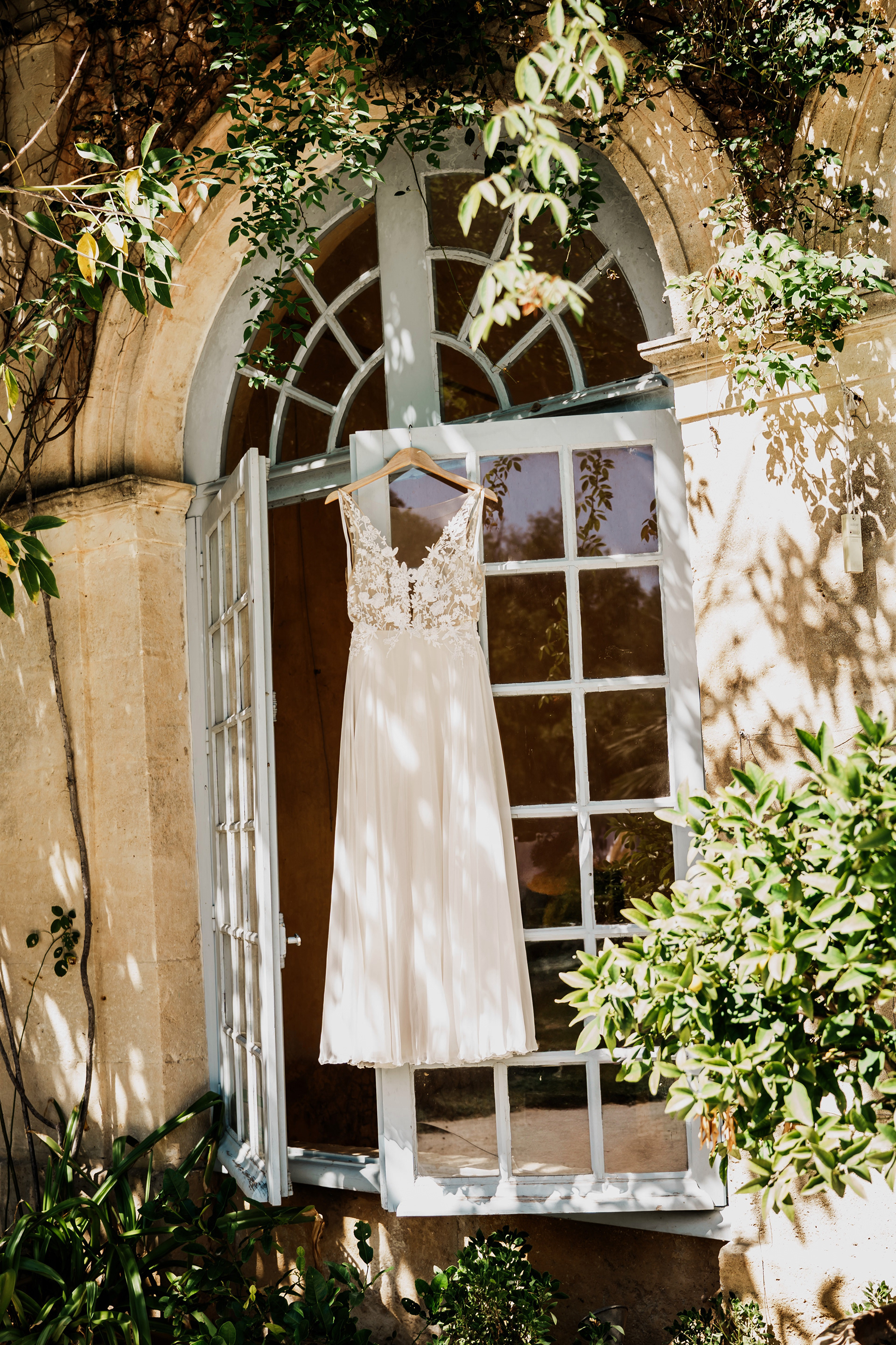 robe de mariée suspendue à une fenêtre au Château de Flaugergues à Montpellier, mariage Elze & Neil