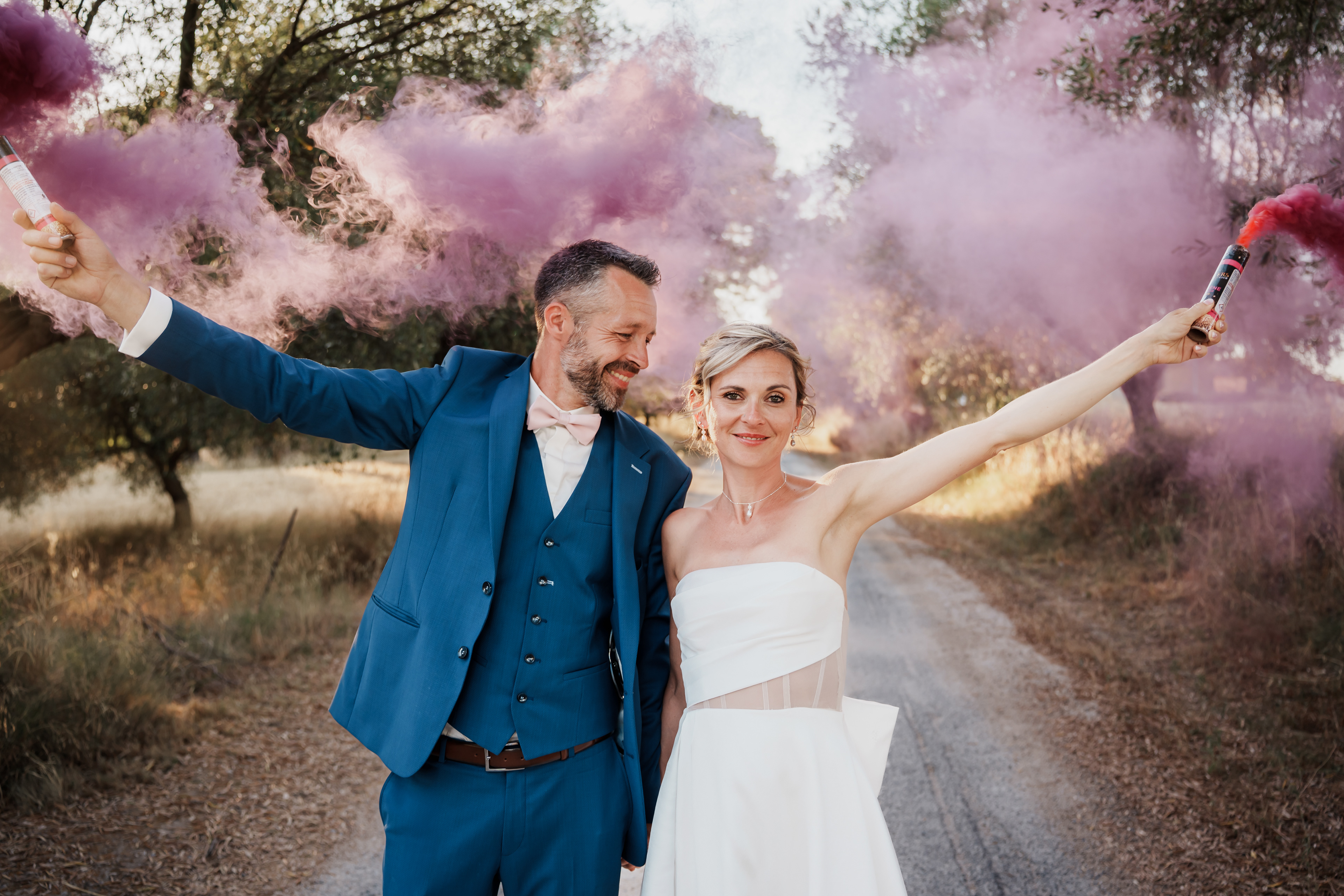 Couple de mariés avec fumigènes roses lors d’une séance photo de mariage dans l’Hérault